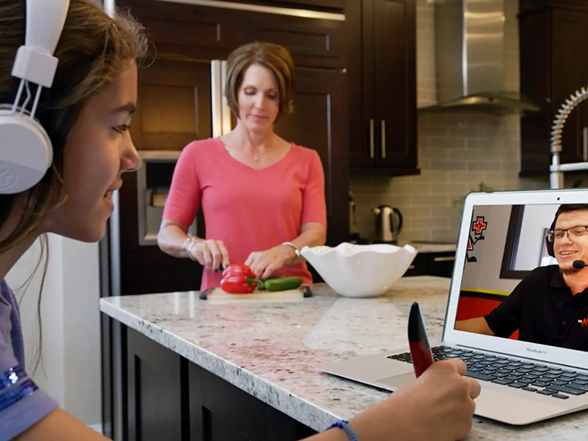 a person wearing headphones and sitting at a table with a laptop