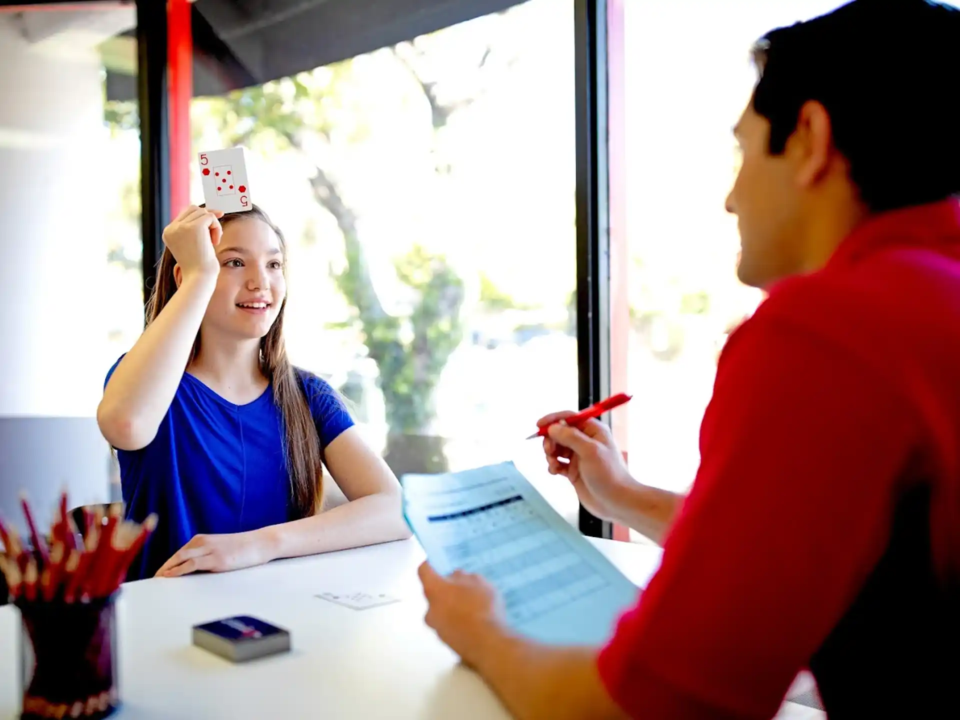 a woman taking a picture of a man sitting at a table
