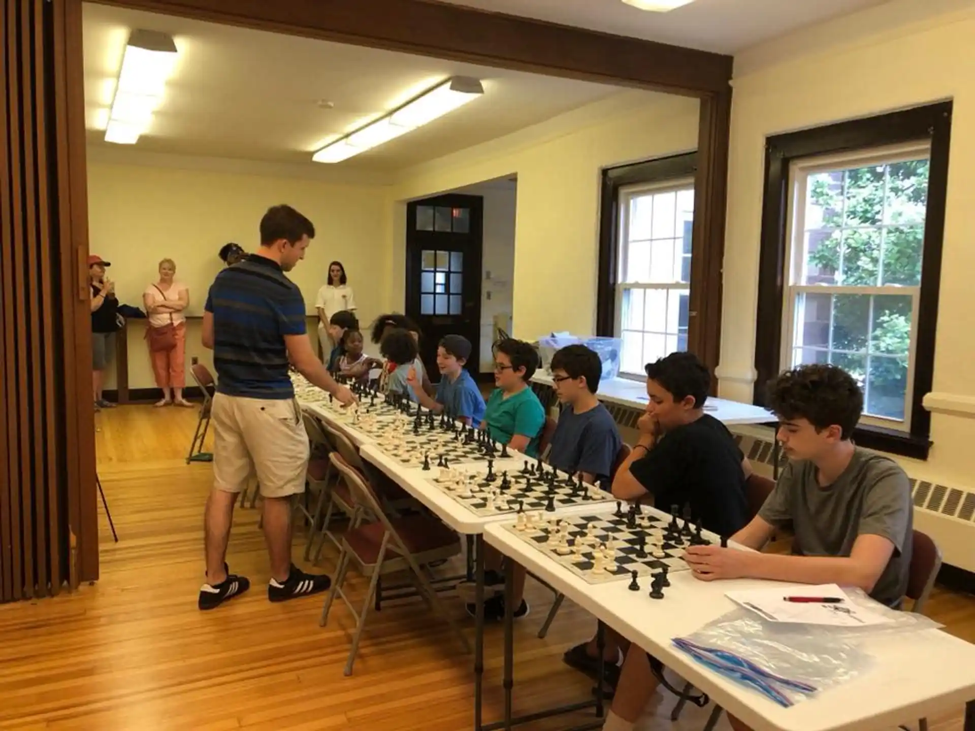 a group of people sitting around a table playing chess