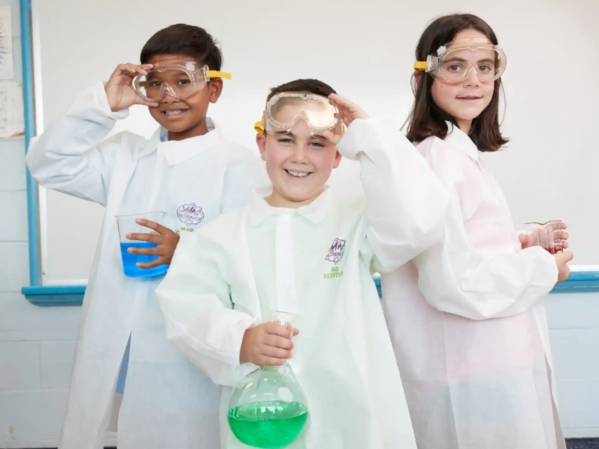 a group of people wearing lab coats and holding beakers