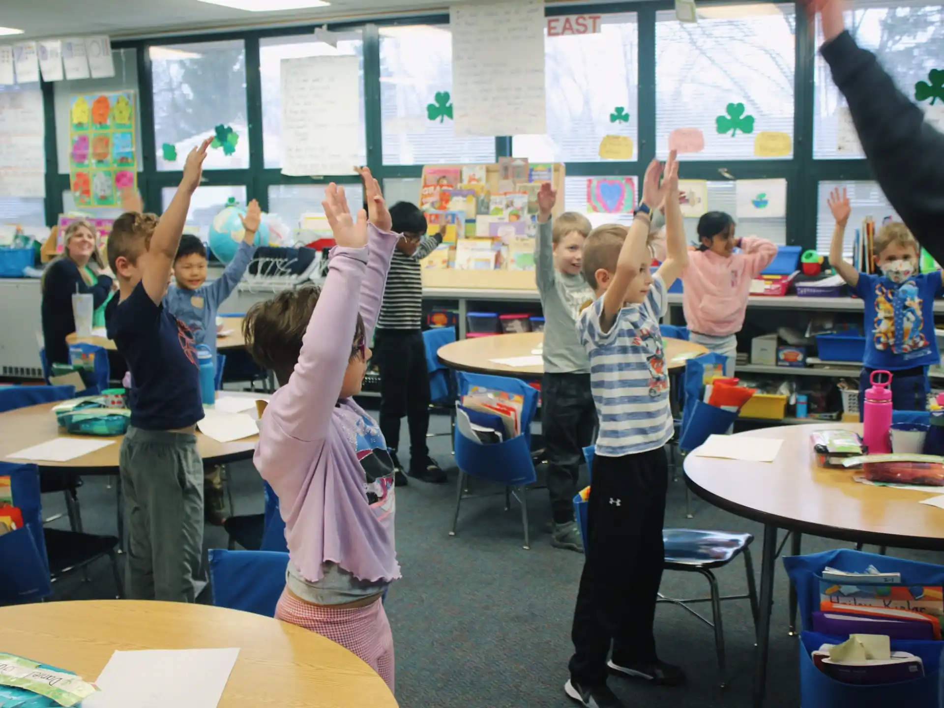a group of children raising their hands