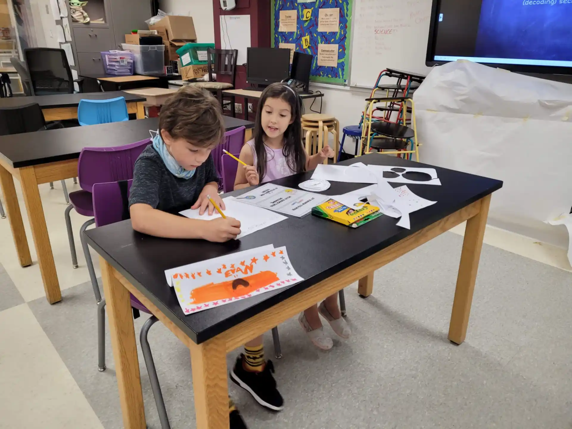 a couple of children sitting at a table with a cake on it