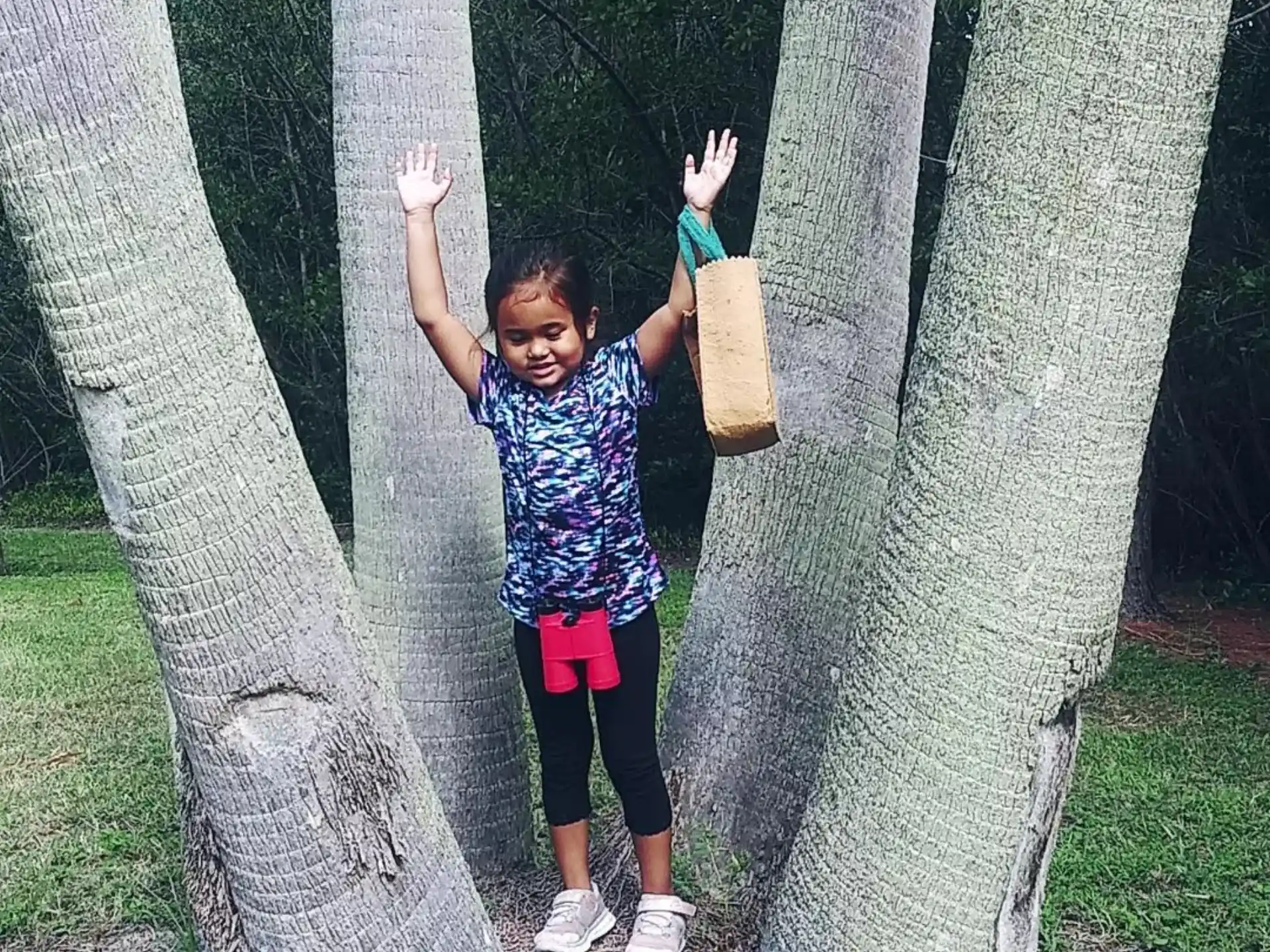 a girl standing between trees