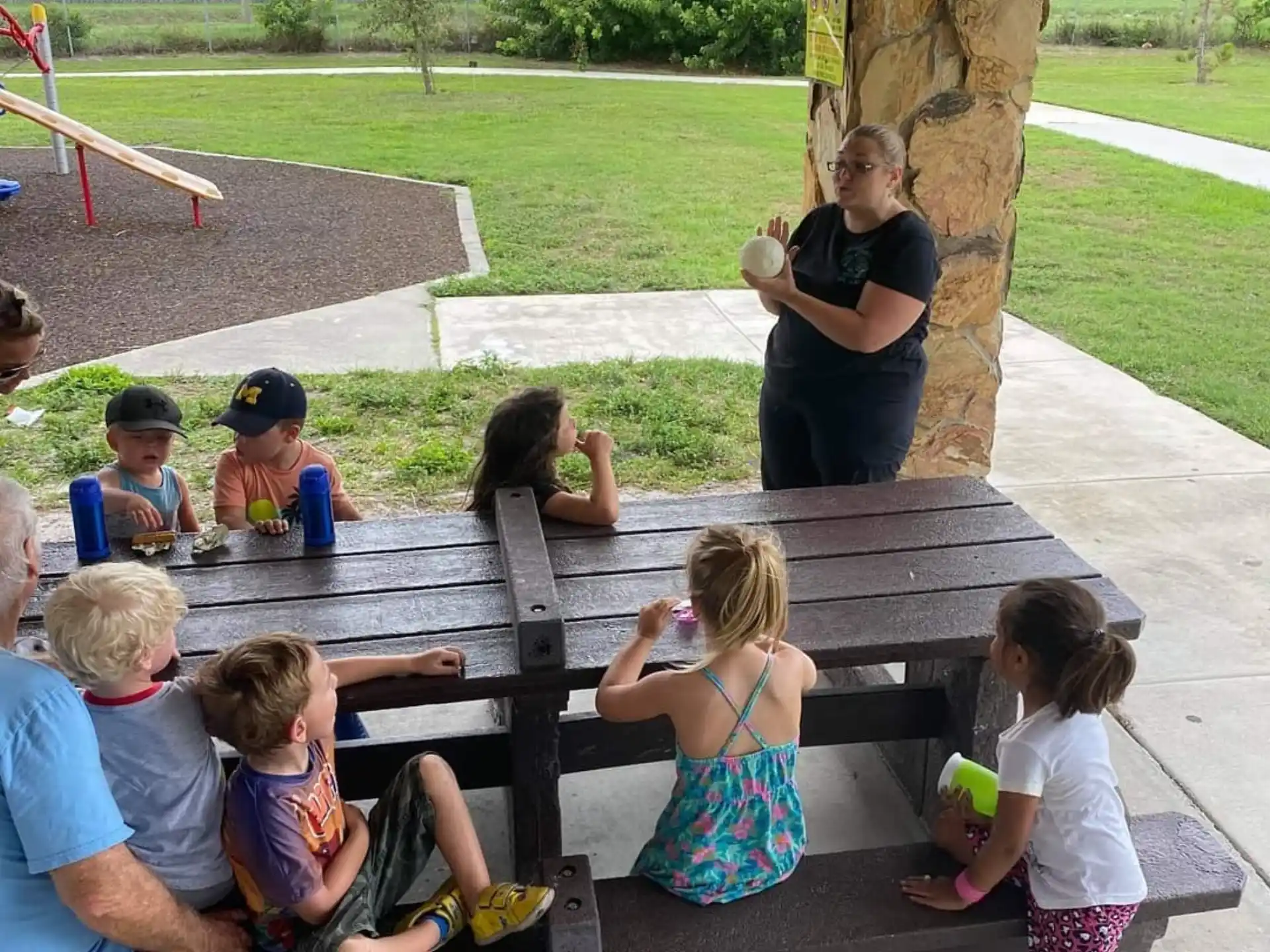 a group of people sitting around a picnic table