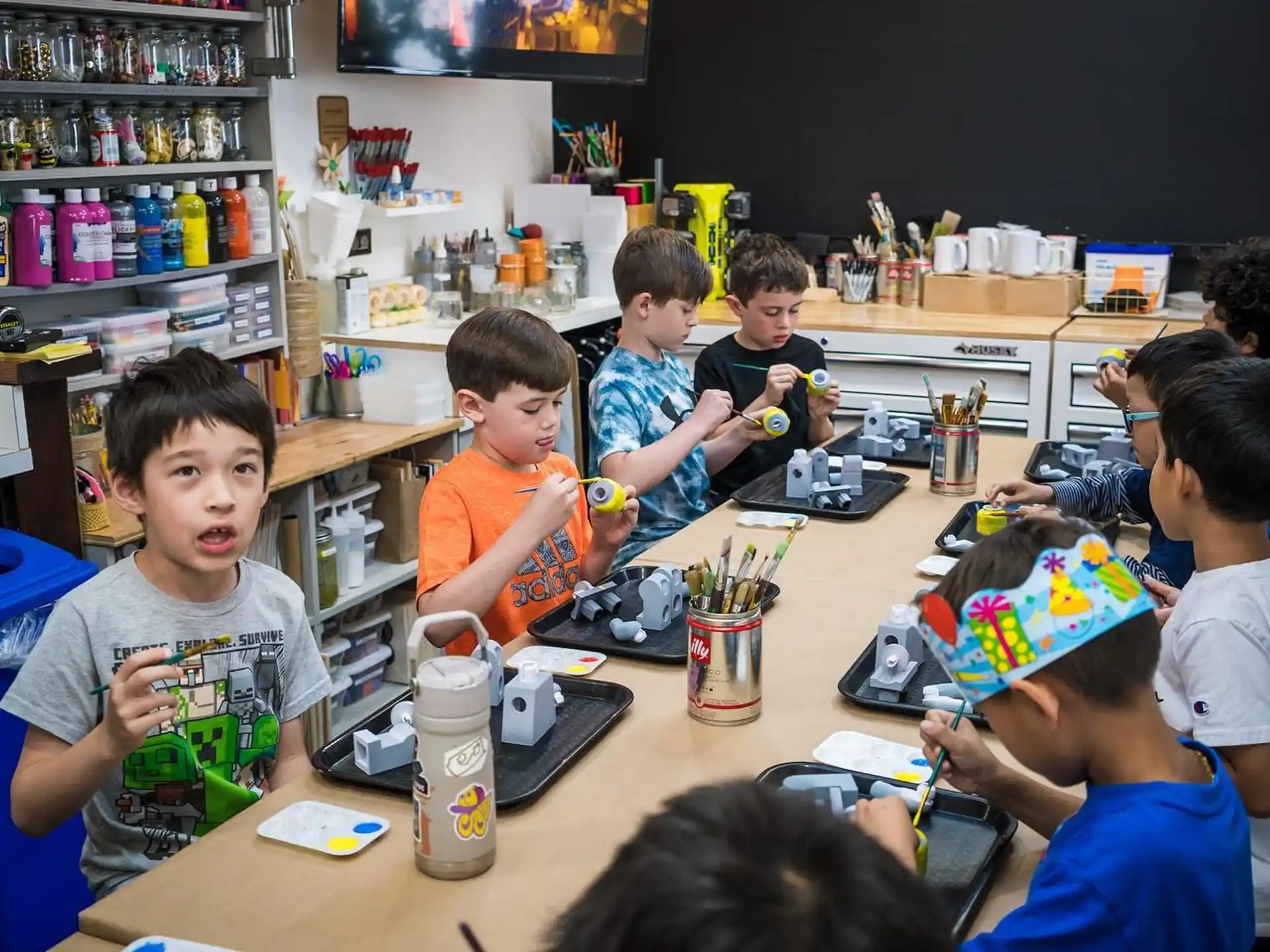 a group of kids sitting at a table playing with a toy