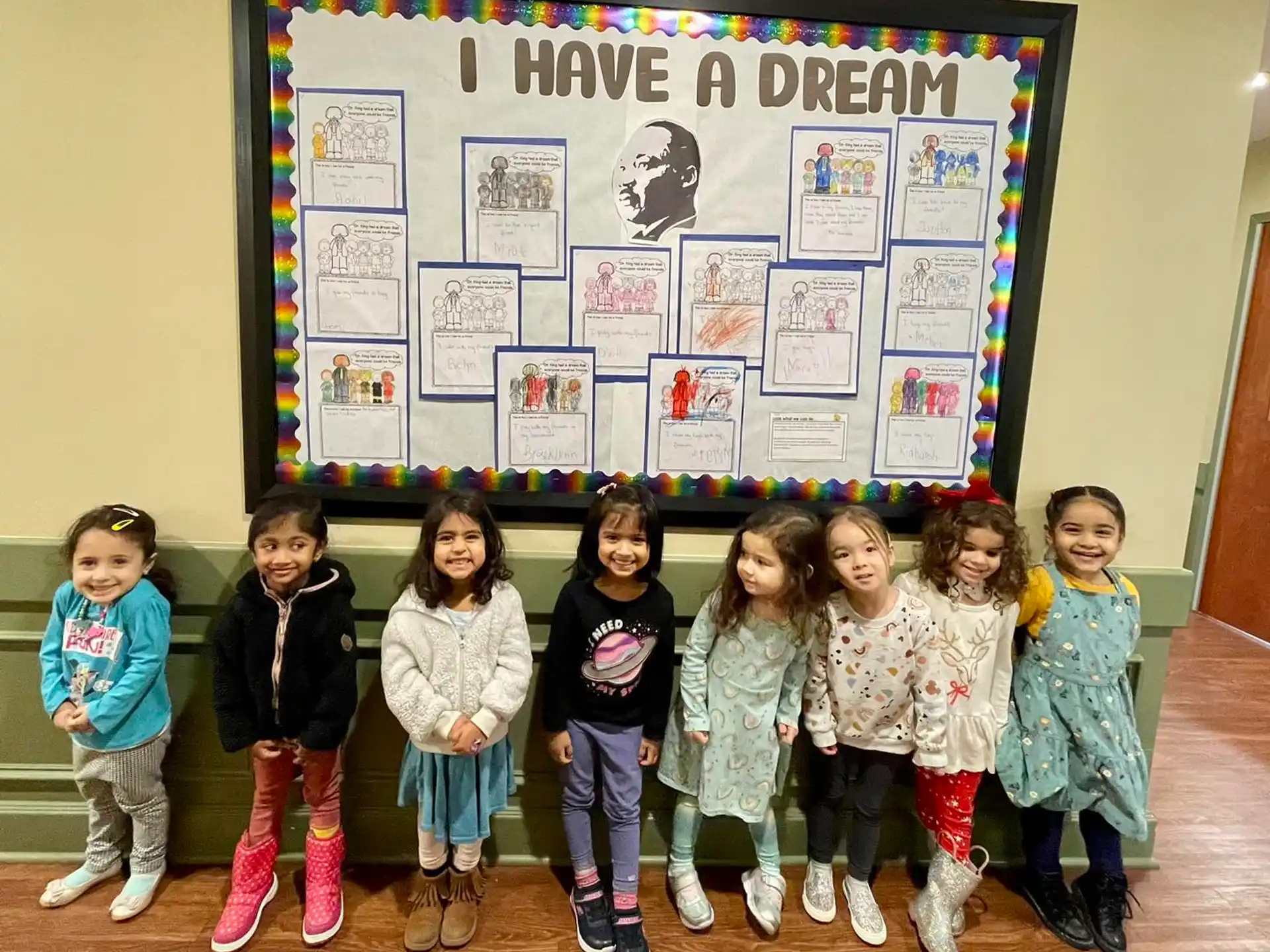 a group of children posing for a photo in front of a poster