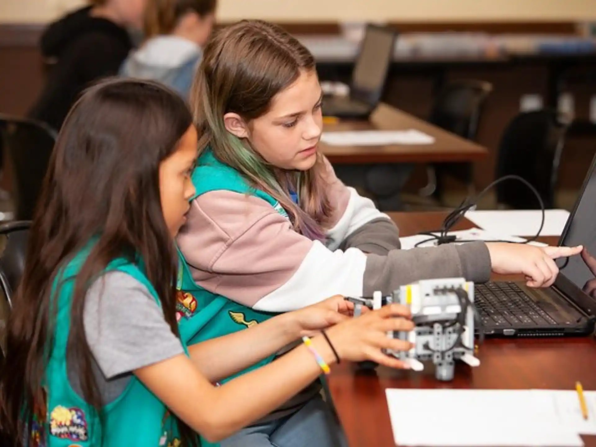 a few young girls working on a laptop