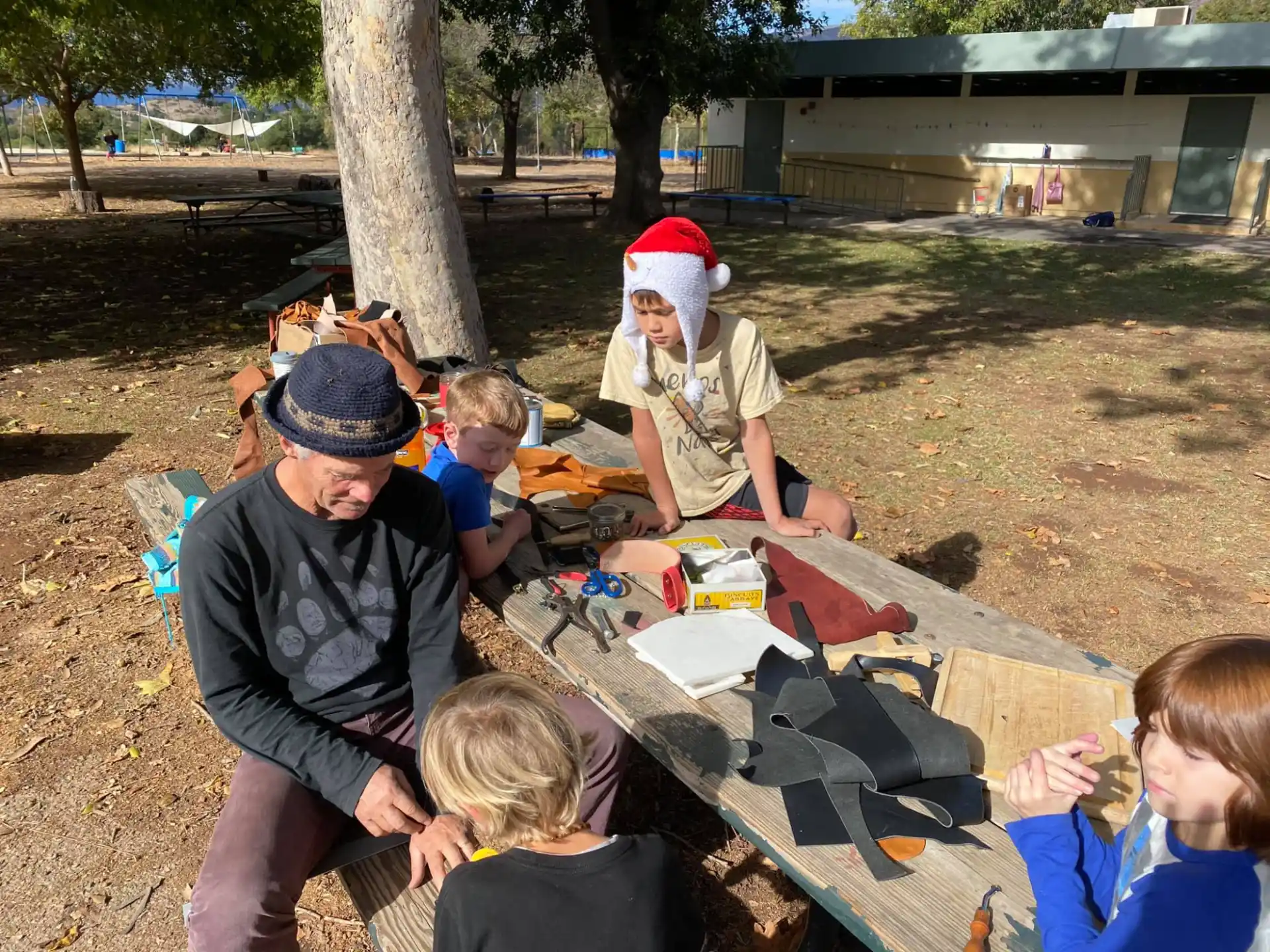 a group of people sitting around a table outside