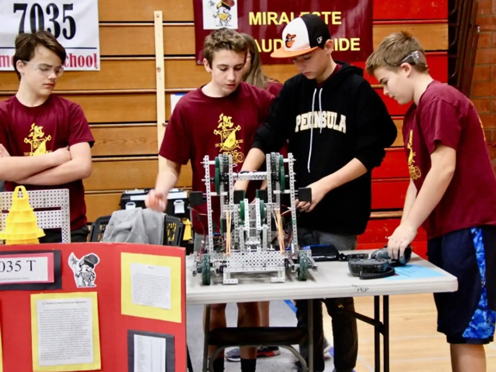 a group of people standing around a table with a trophy
