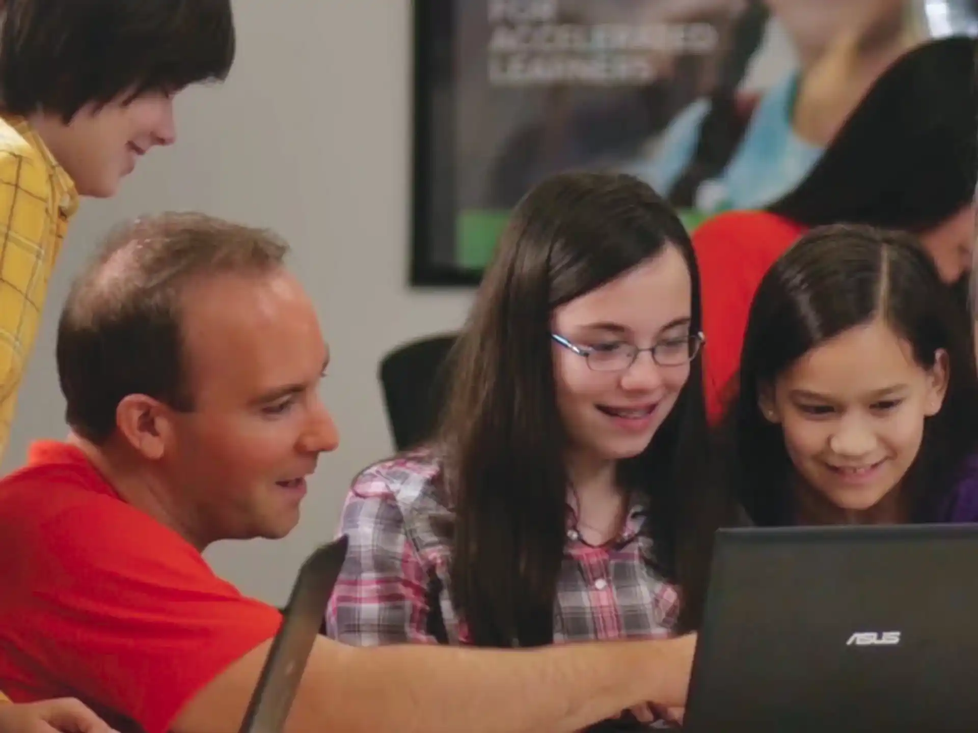 a group of people looking at a laptop