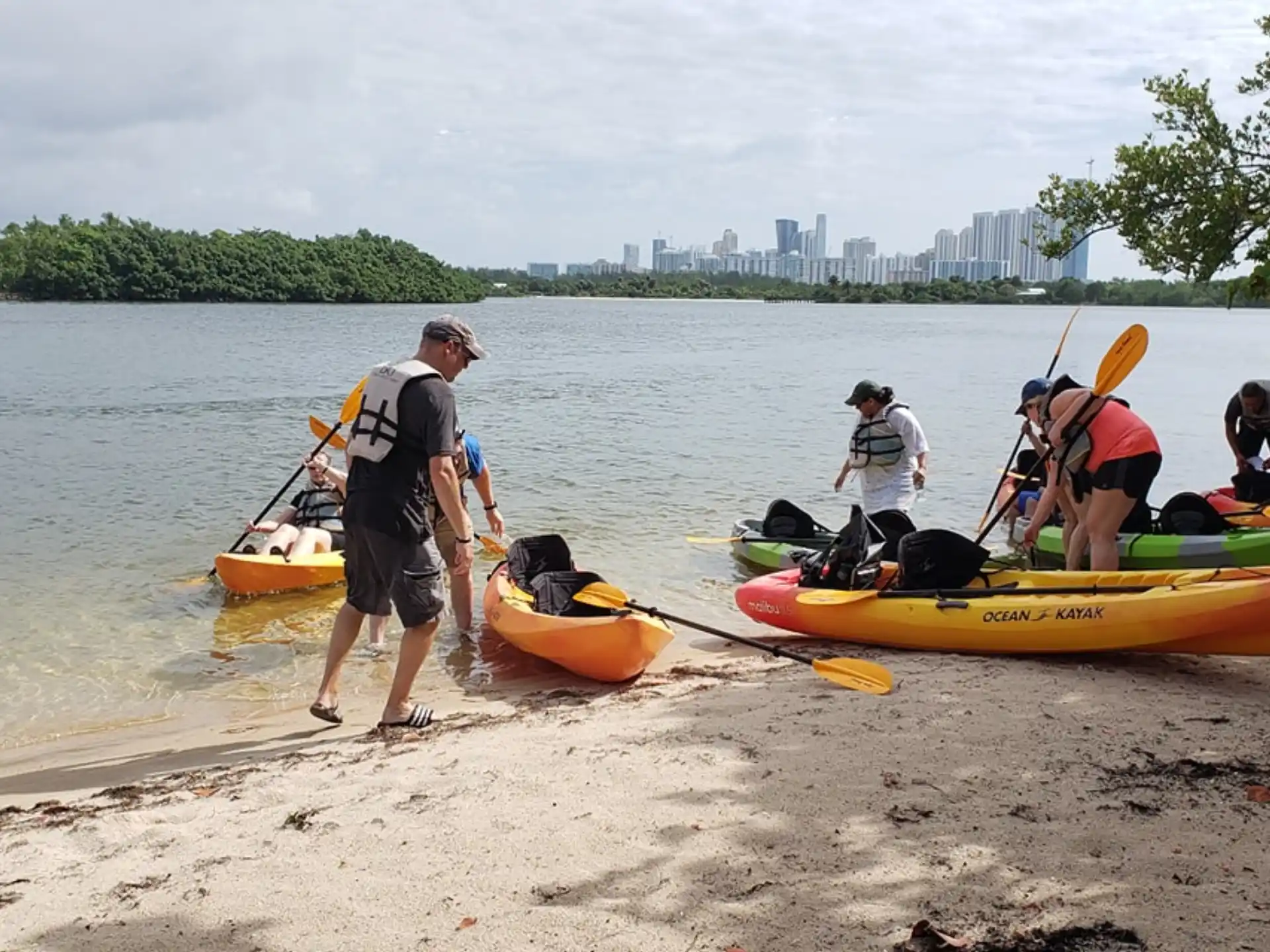 a group of people with kayaks on a beach