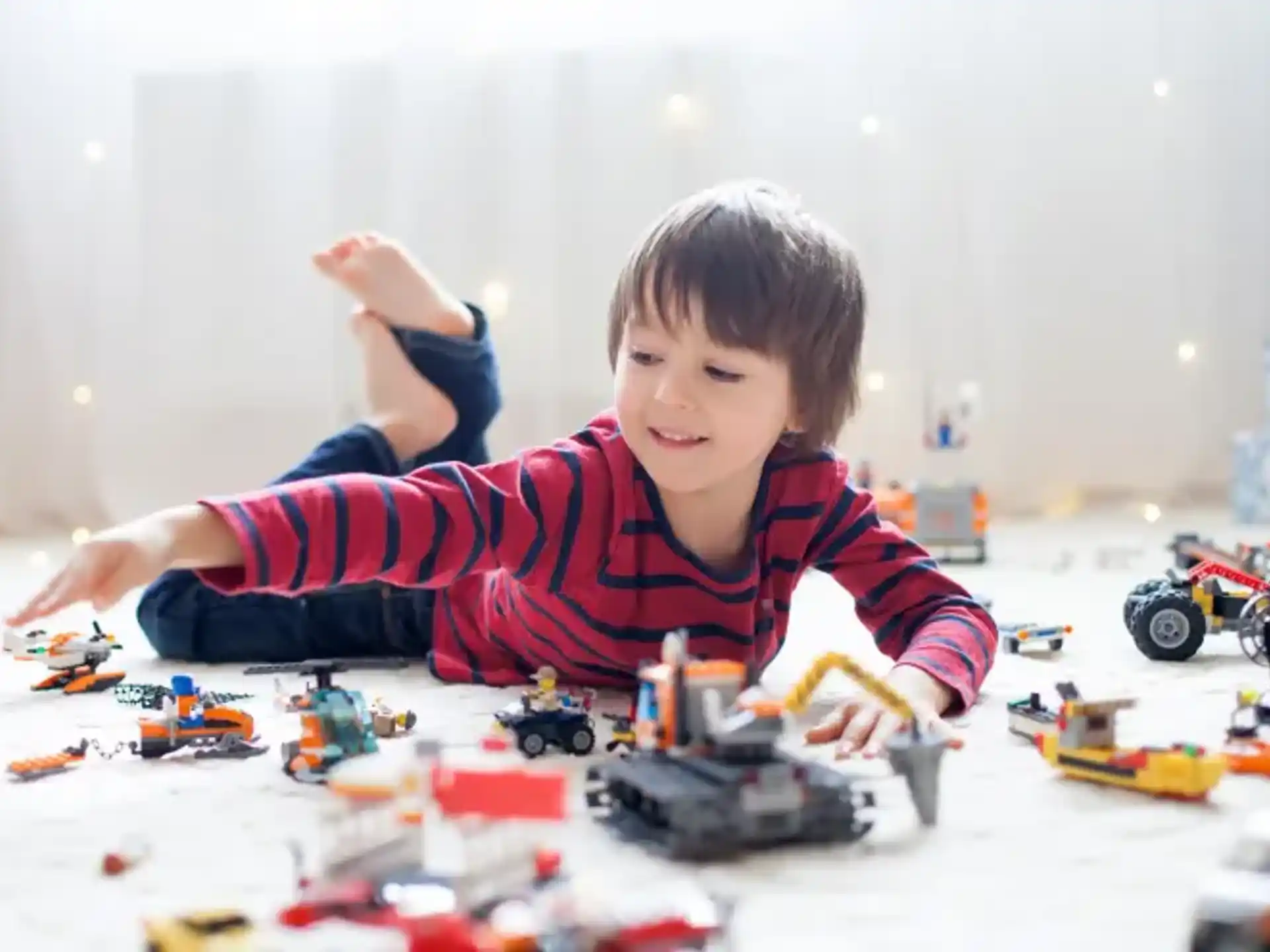 a boy lying on the floor with toys