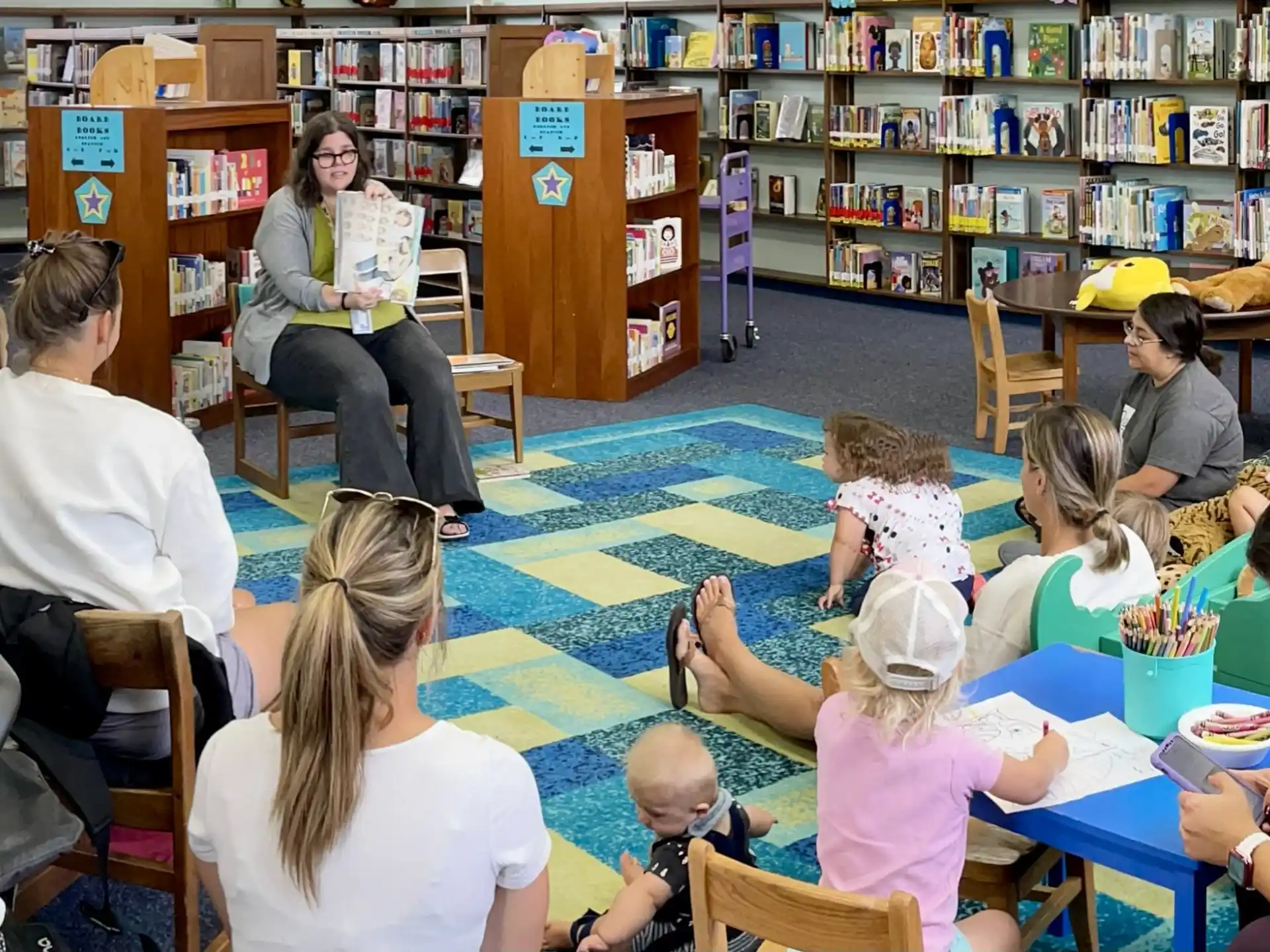 a group of people sitting at tables in a library