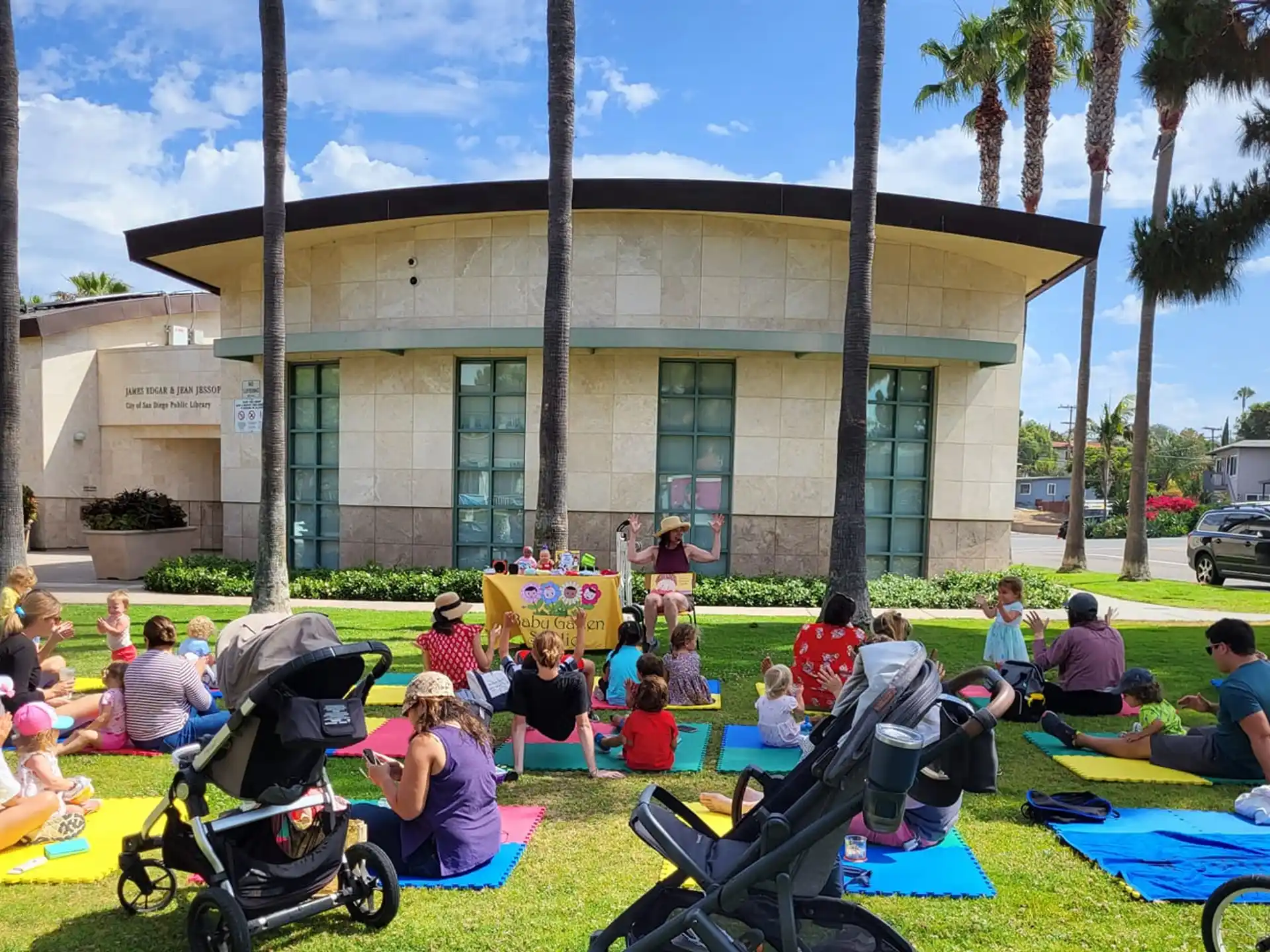 a group of people sitting on the grass in front of a building