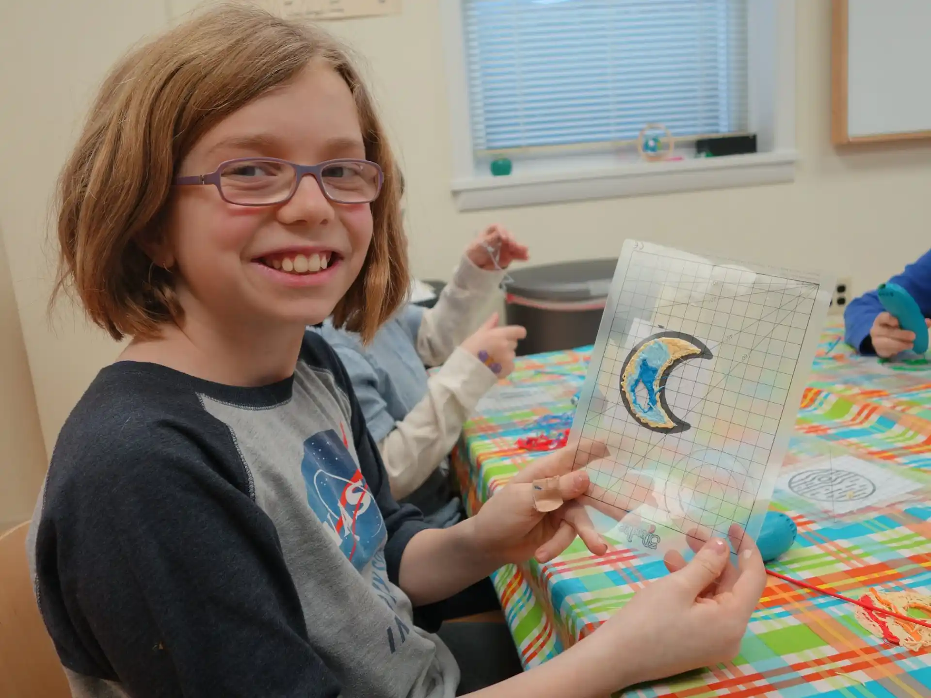 a girl holding a drawing