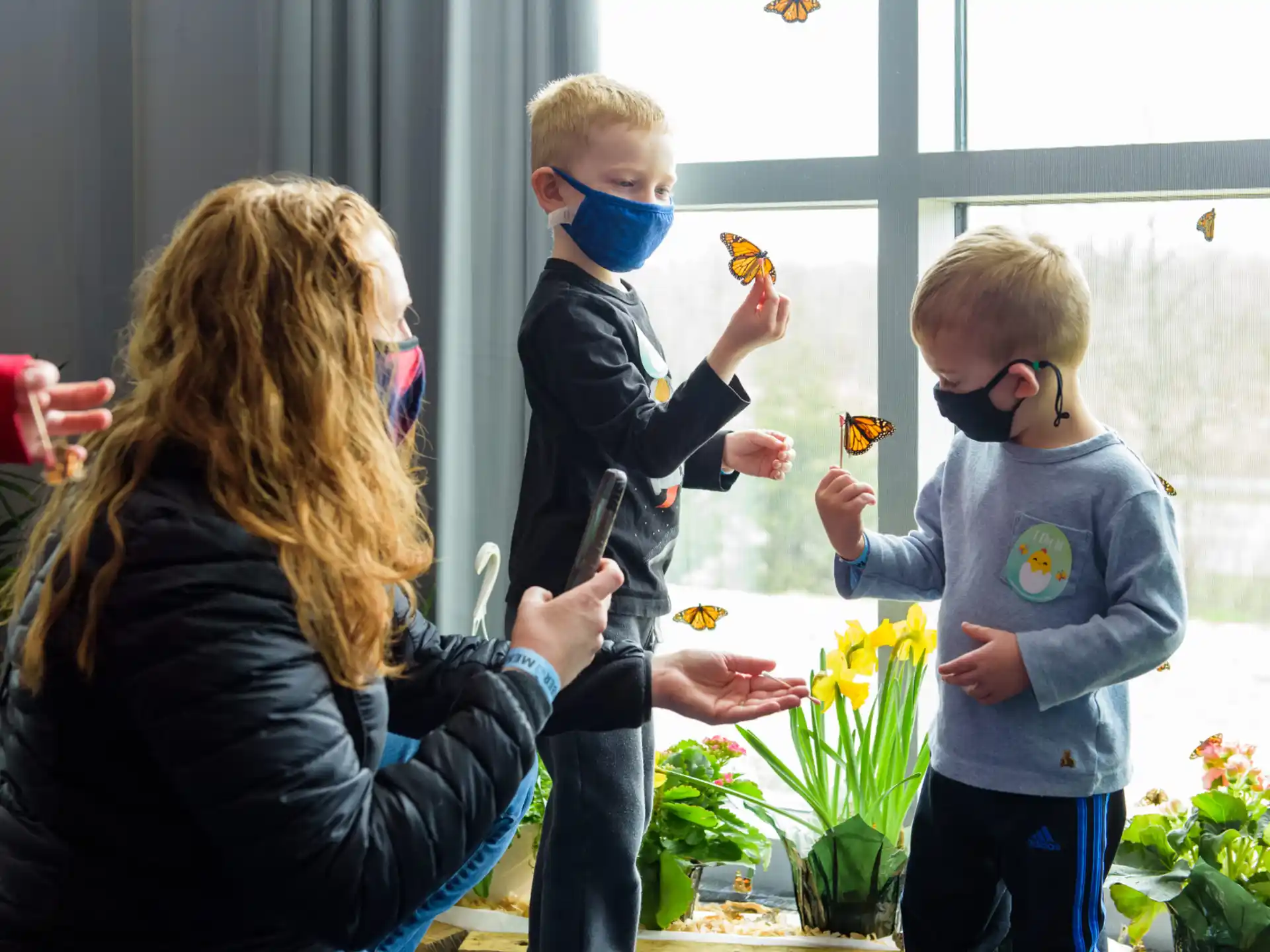 a woman and two children wearing masks