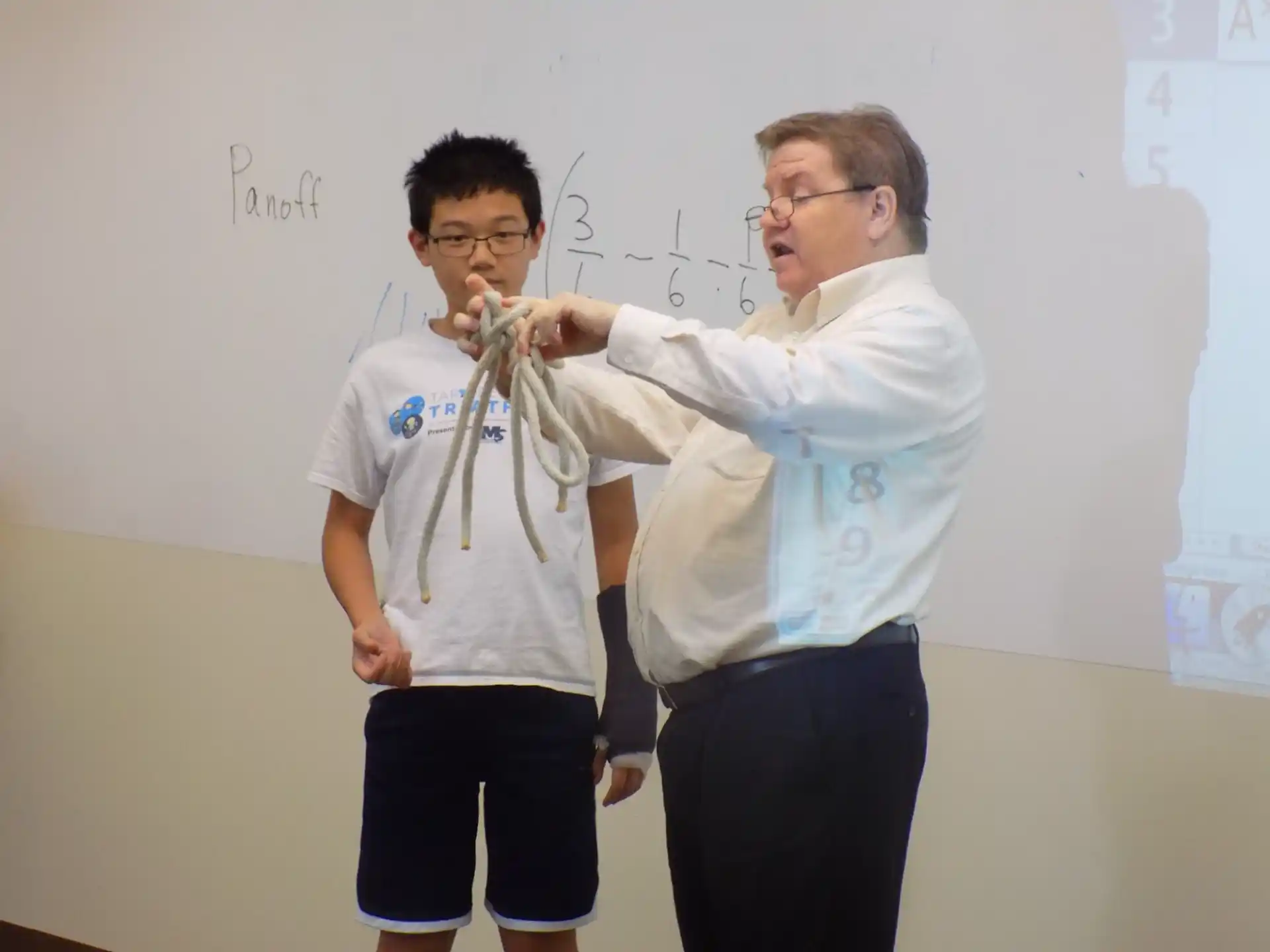 a couple of men in front of a whiteboard
