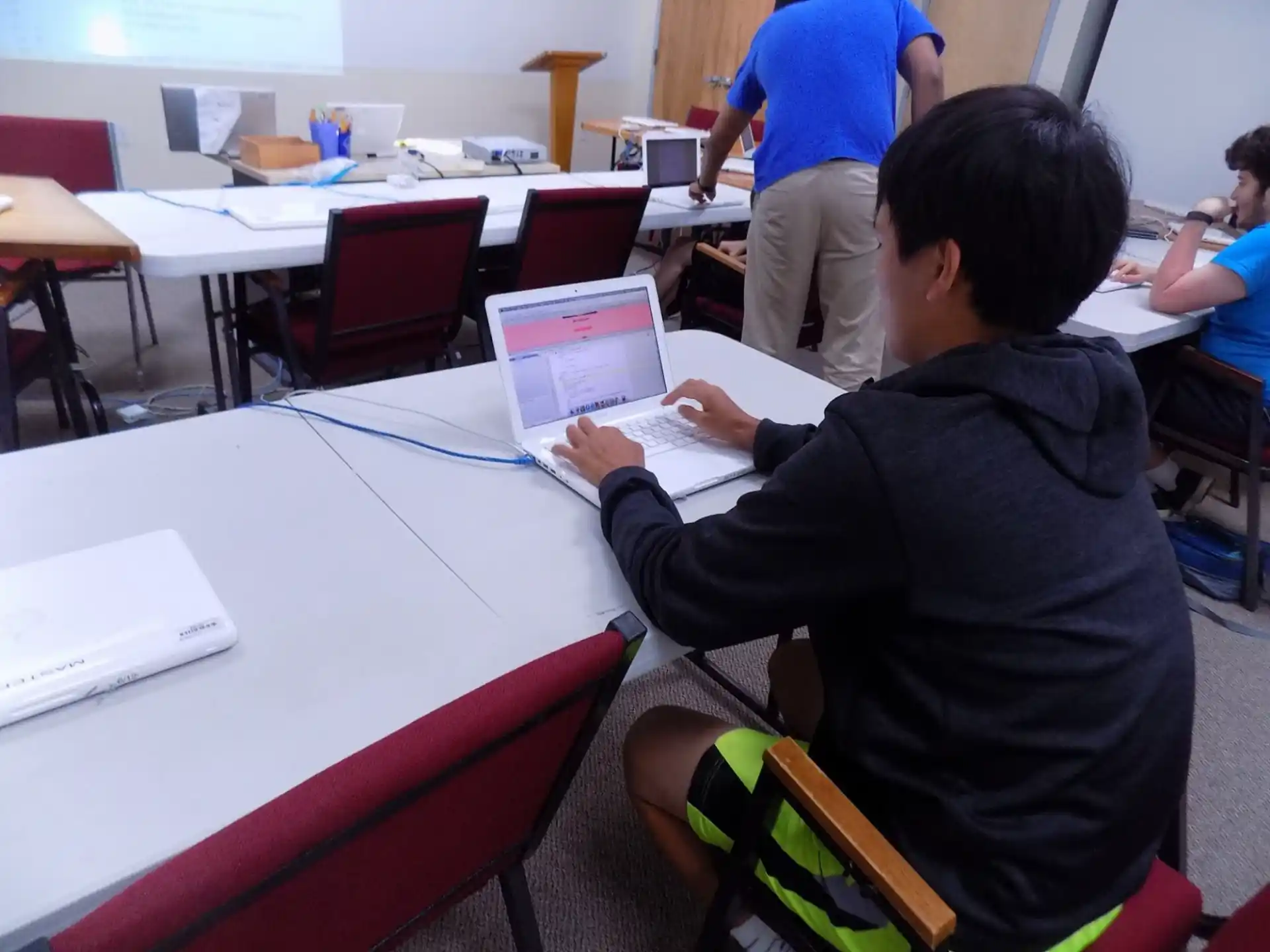 a person sitting at a table using a laptop