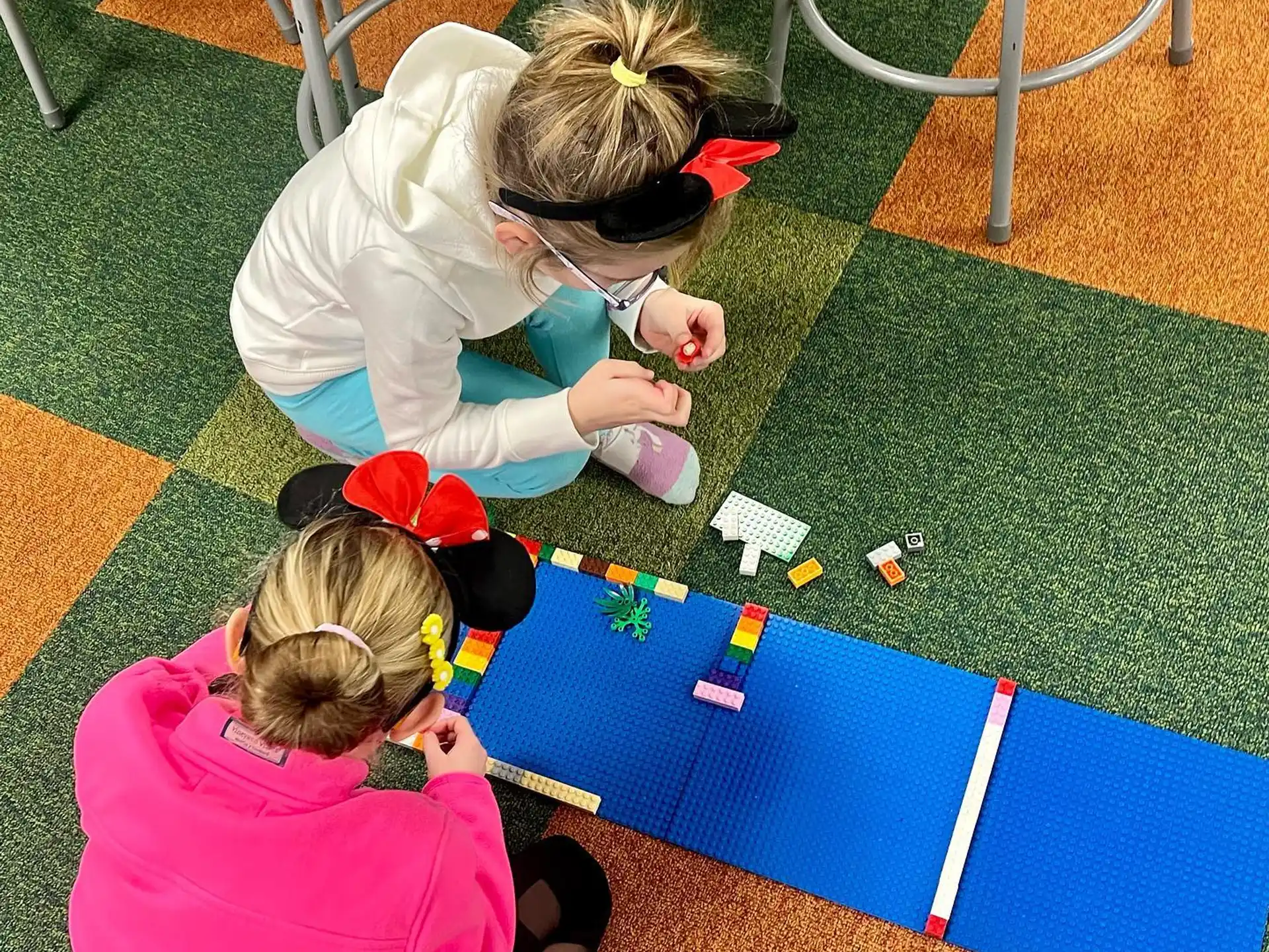 a person and a child playing with toys on the ground