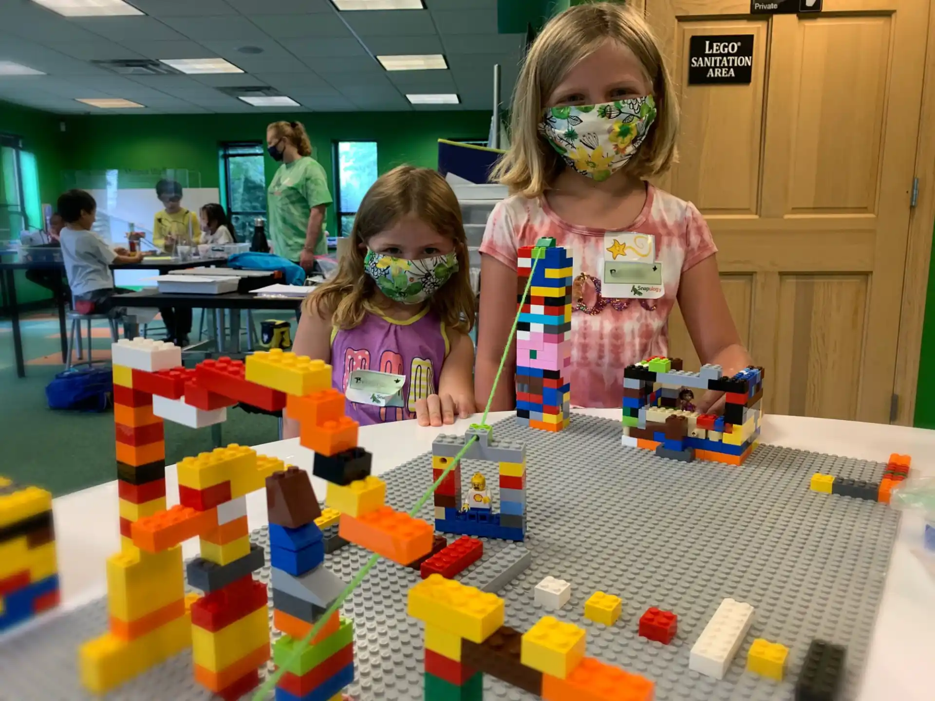 a couple of young girls playing with building blocks