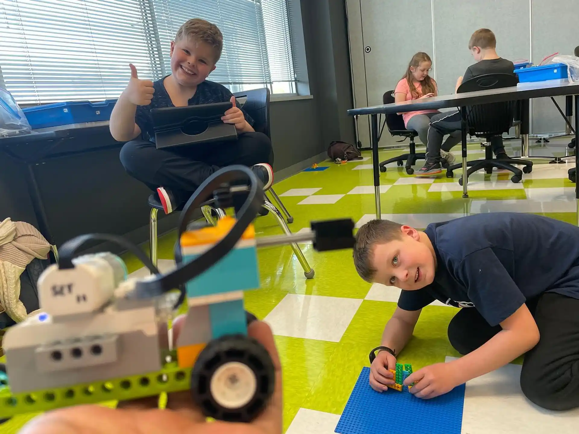 a boy and a girl playing with a toy tractor