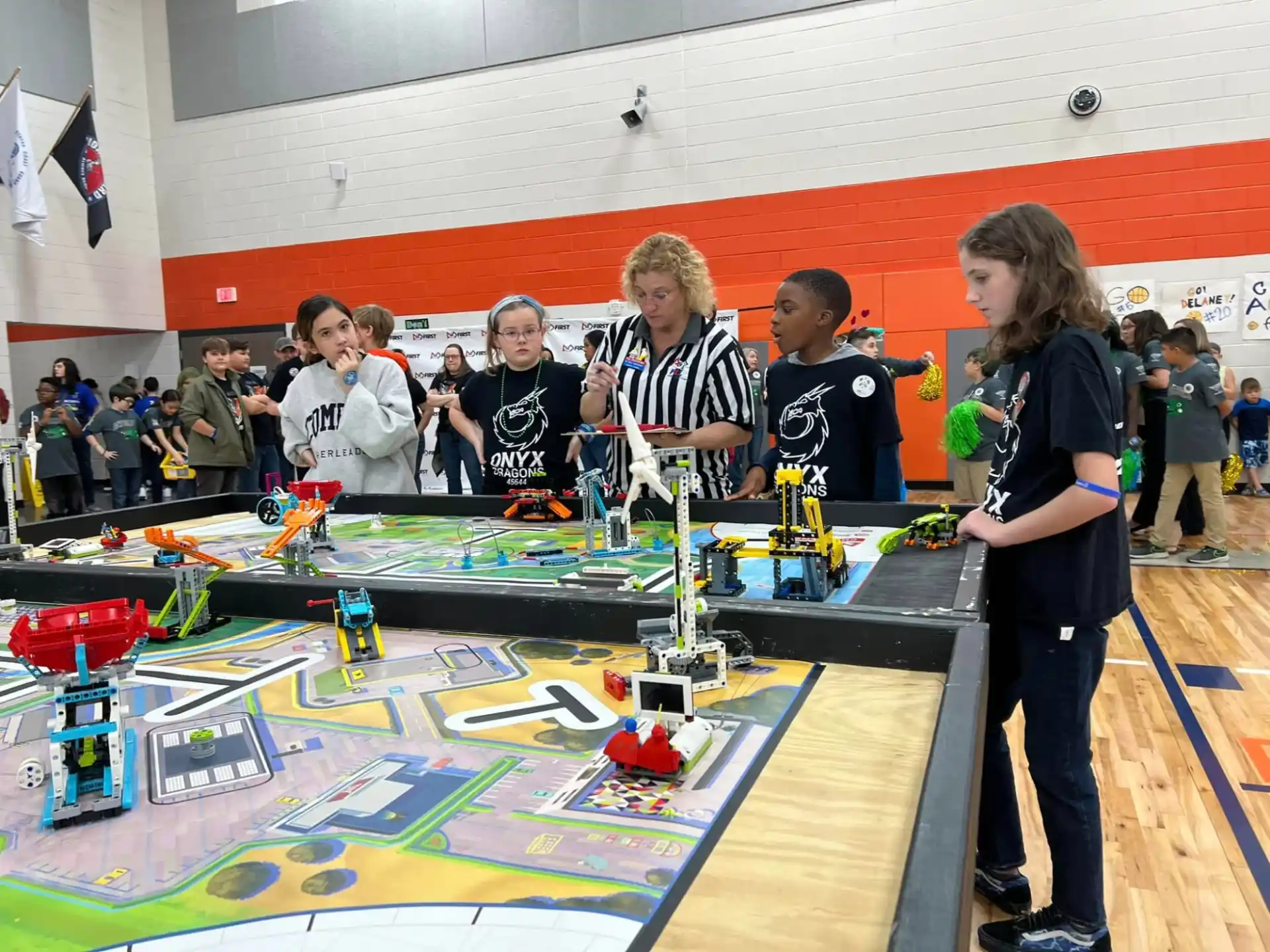 a group of people standing around a table with a model train on it