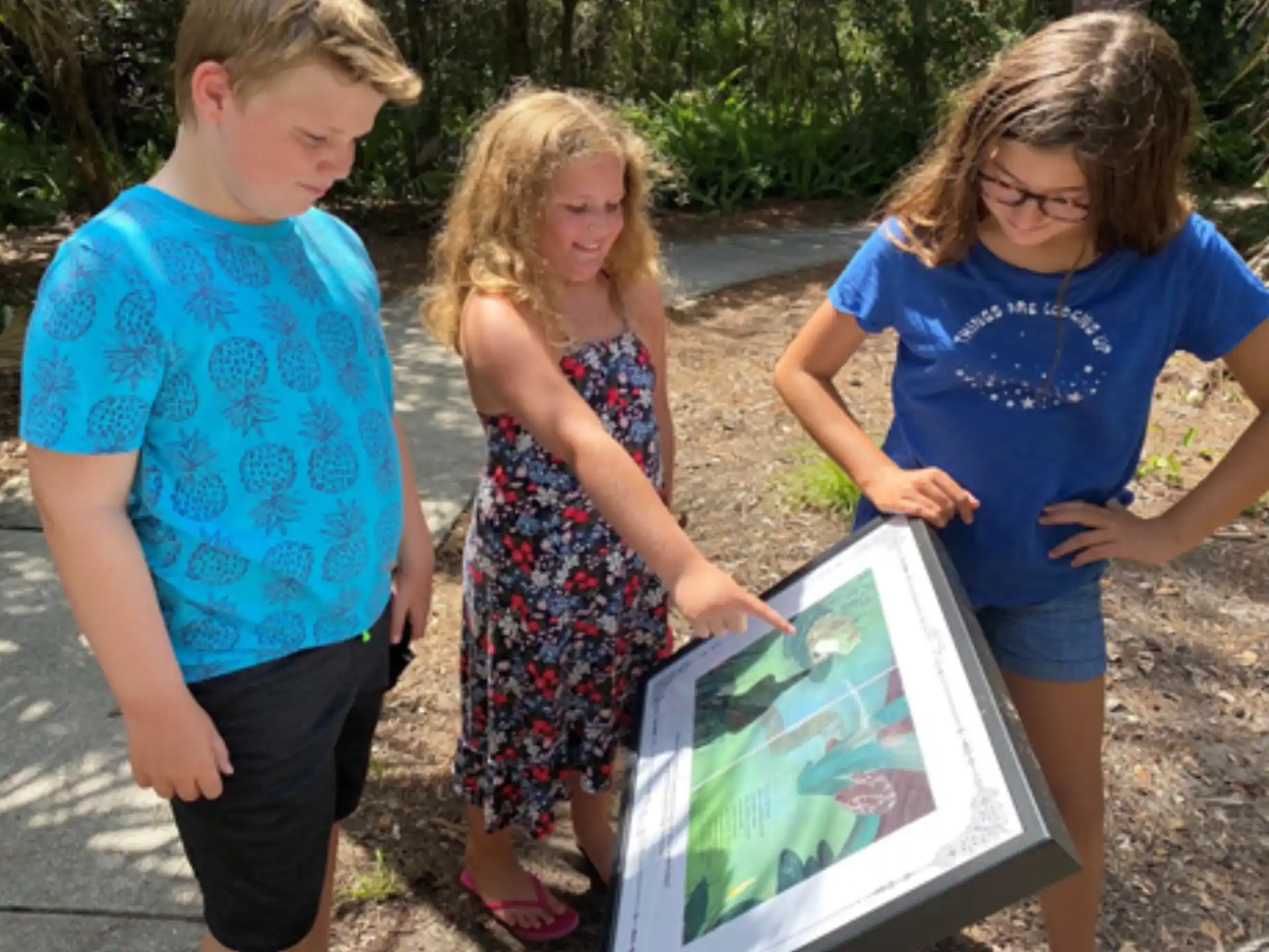 a group of children looking at a picture on a tablet