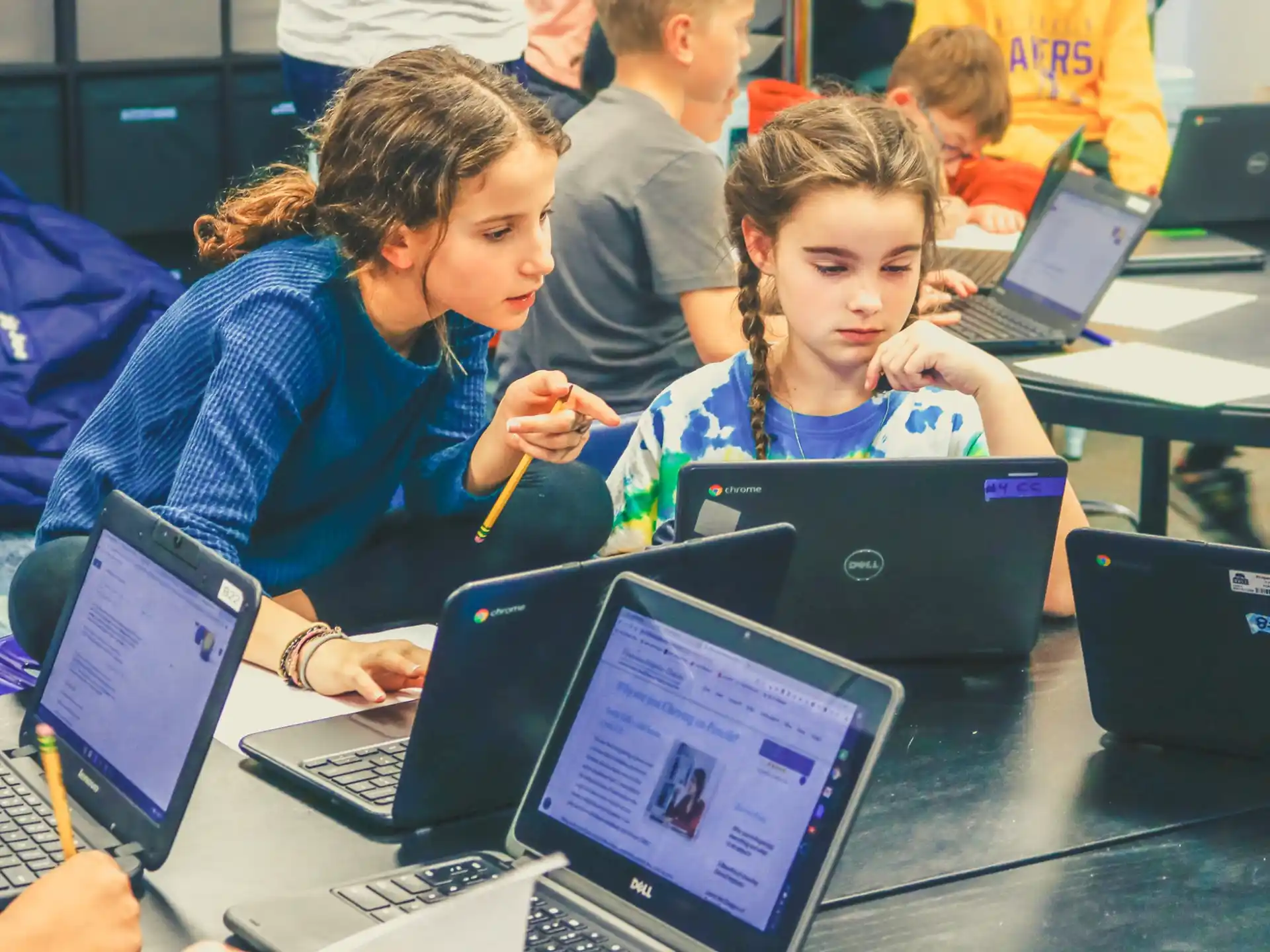 a few children using laptops