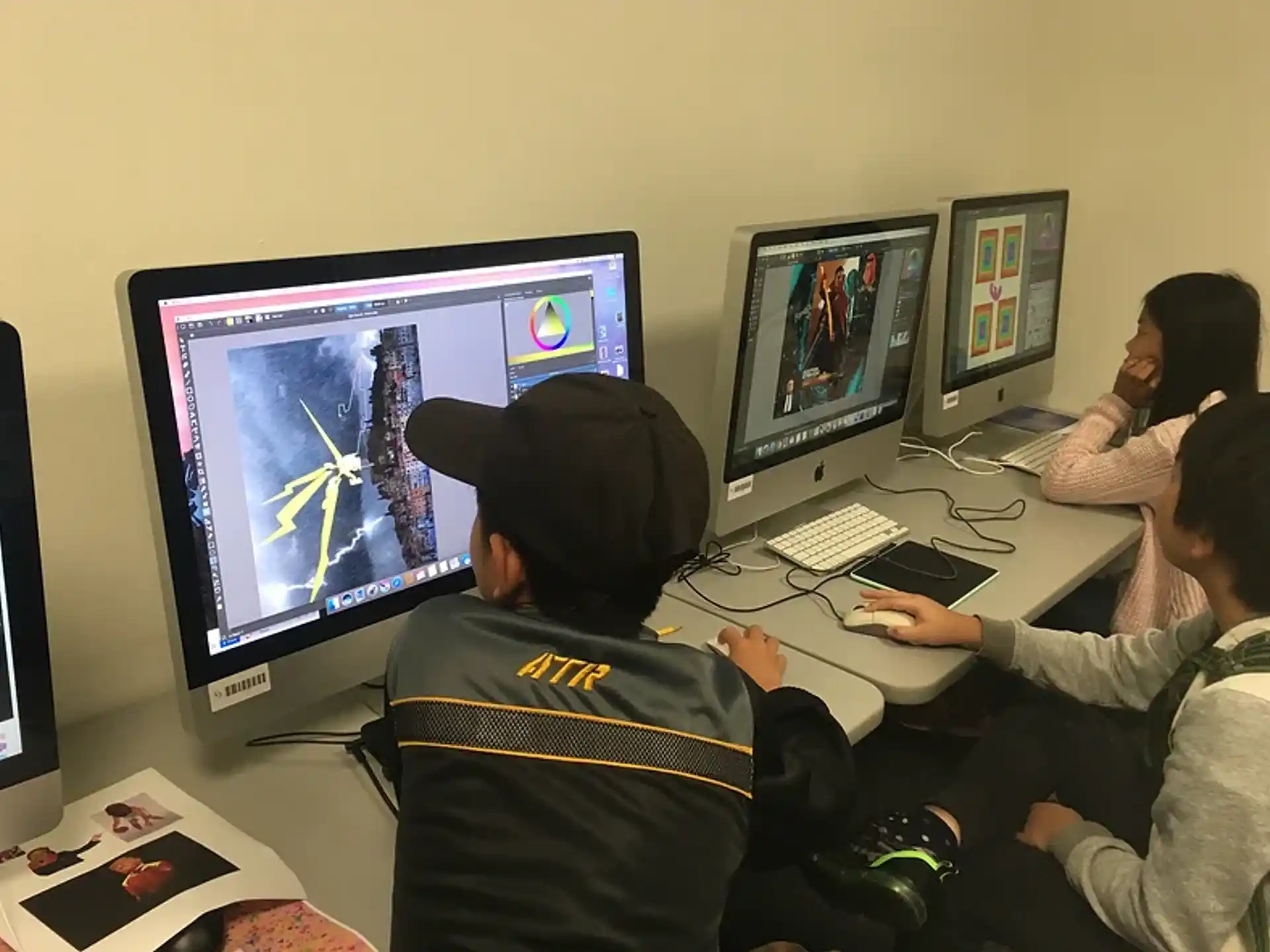 a group of people sitting at a table with computers