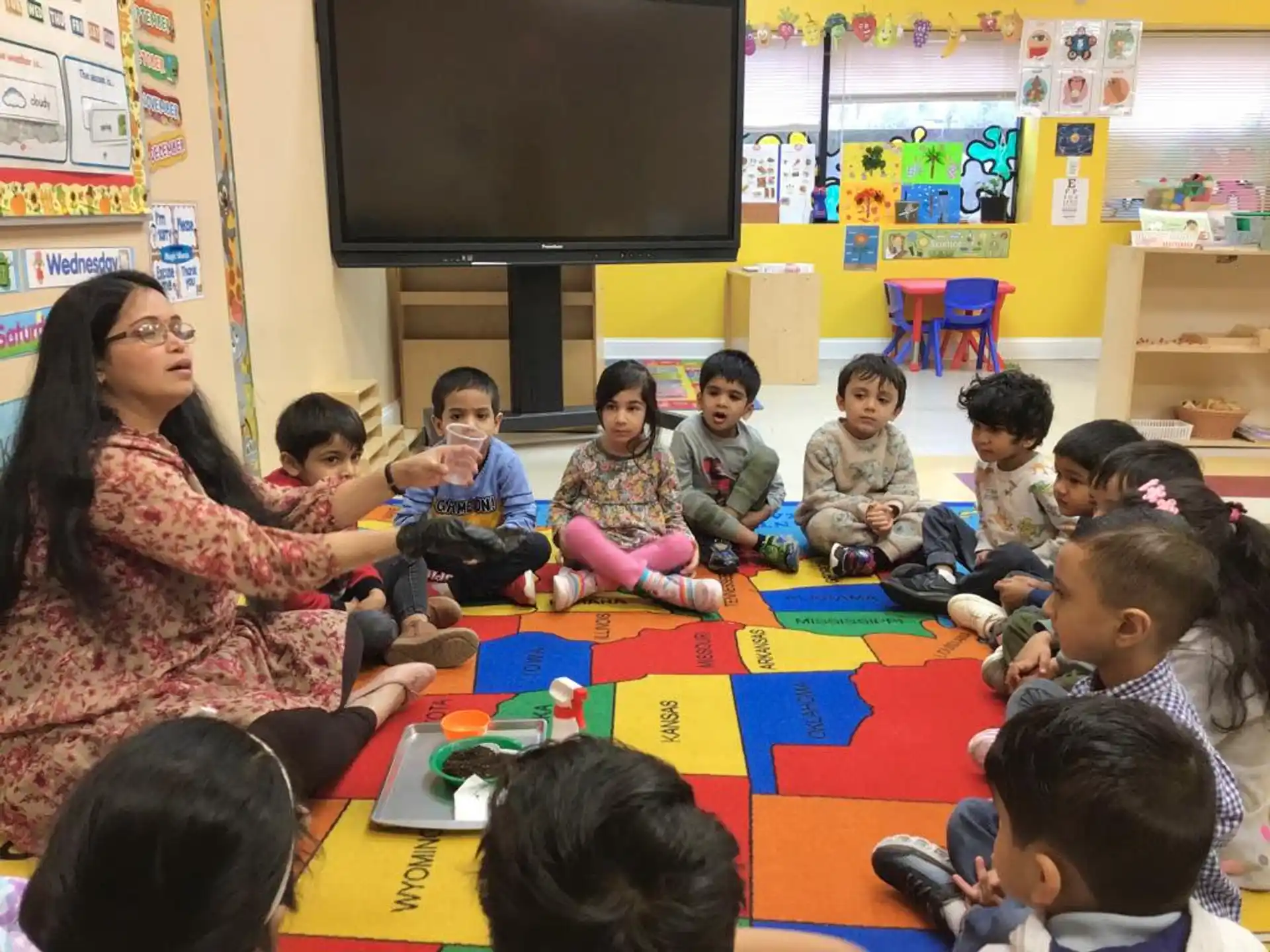 a group of children sitting on the floor in a classroom