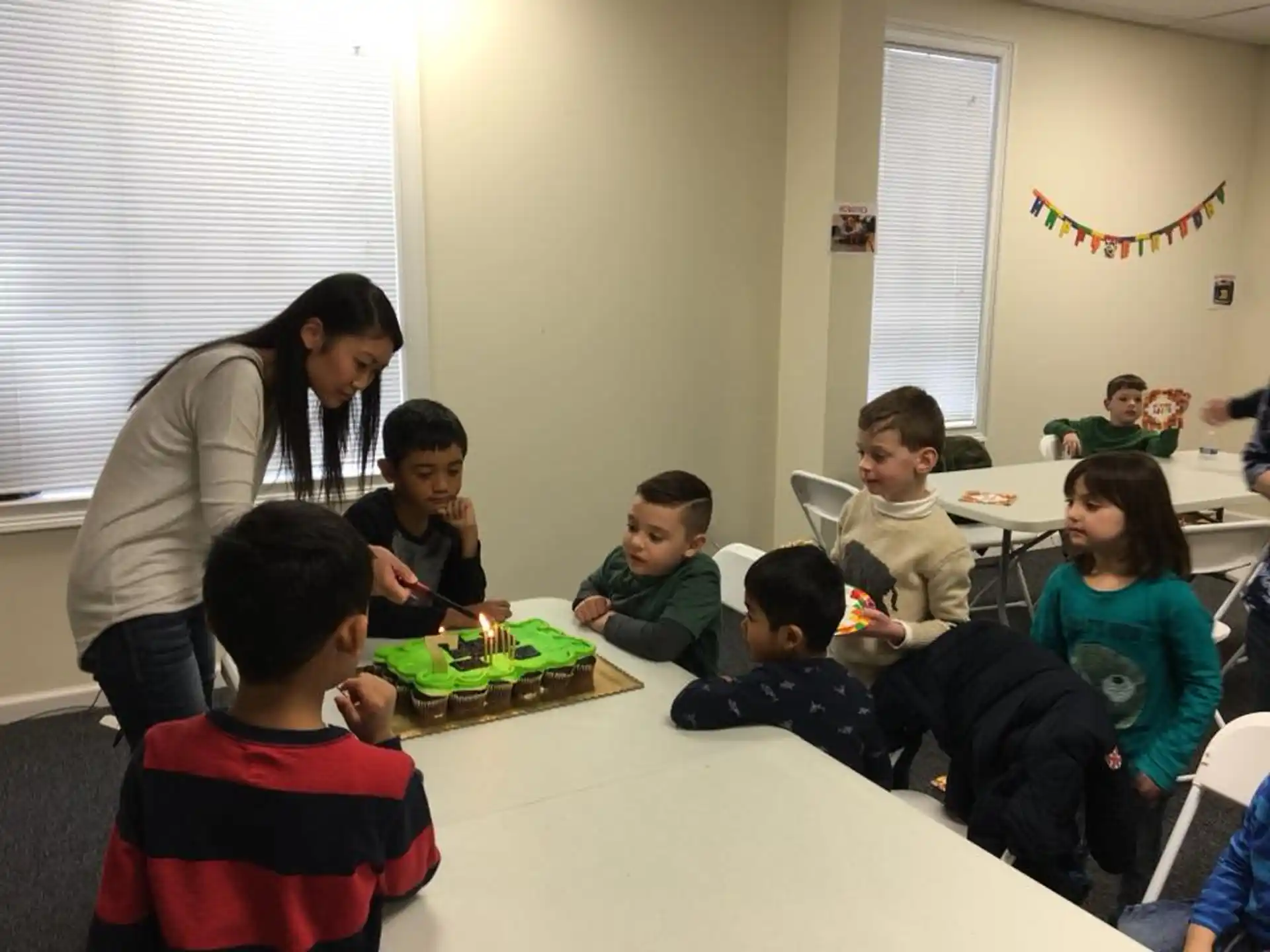 a person and a group of children sitting at a table