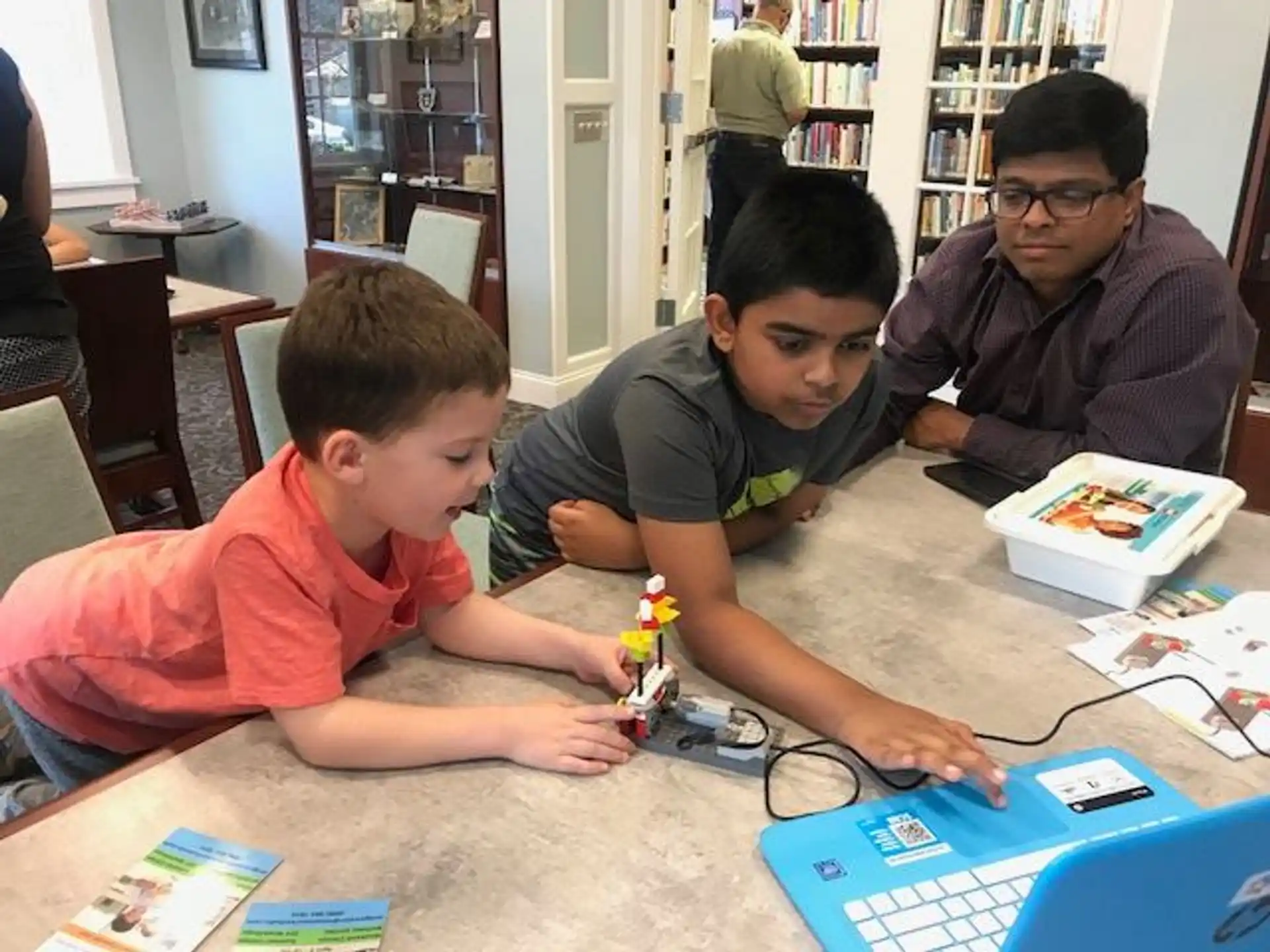 a group of people sitting at a table with a laptop