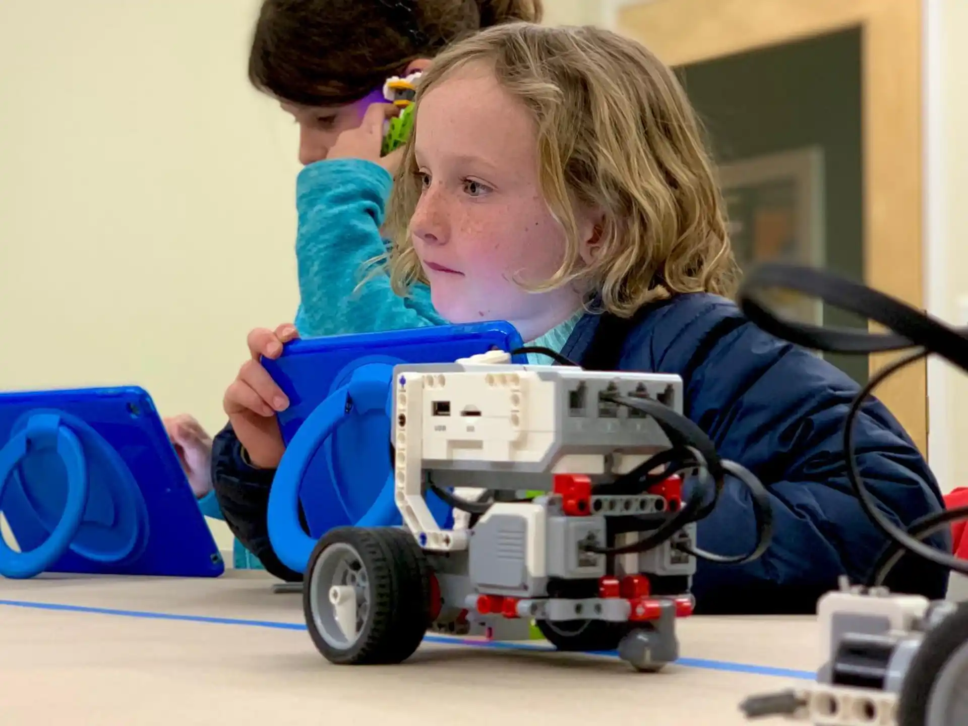 a couple of girls playing with a toy car