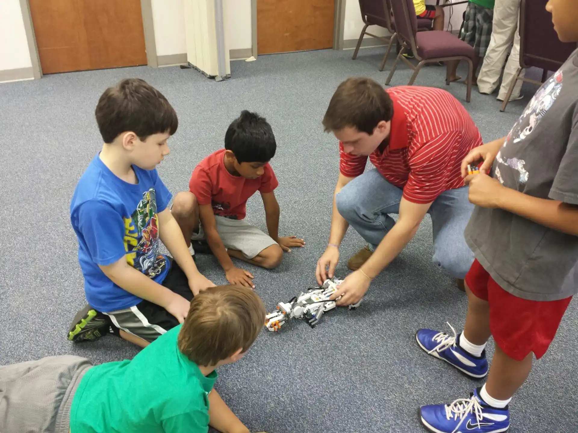 a group of boys playing with a toy airplane on the floor