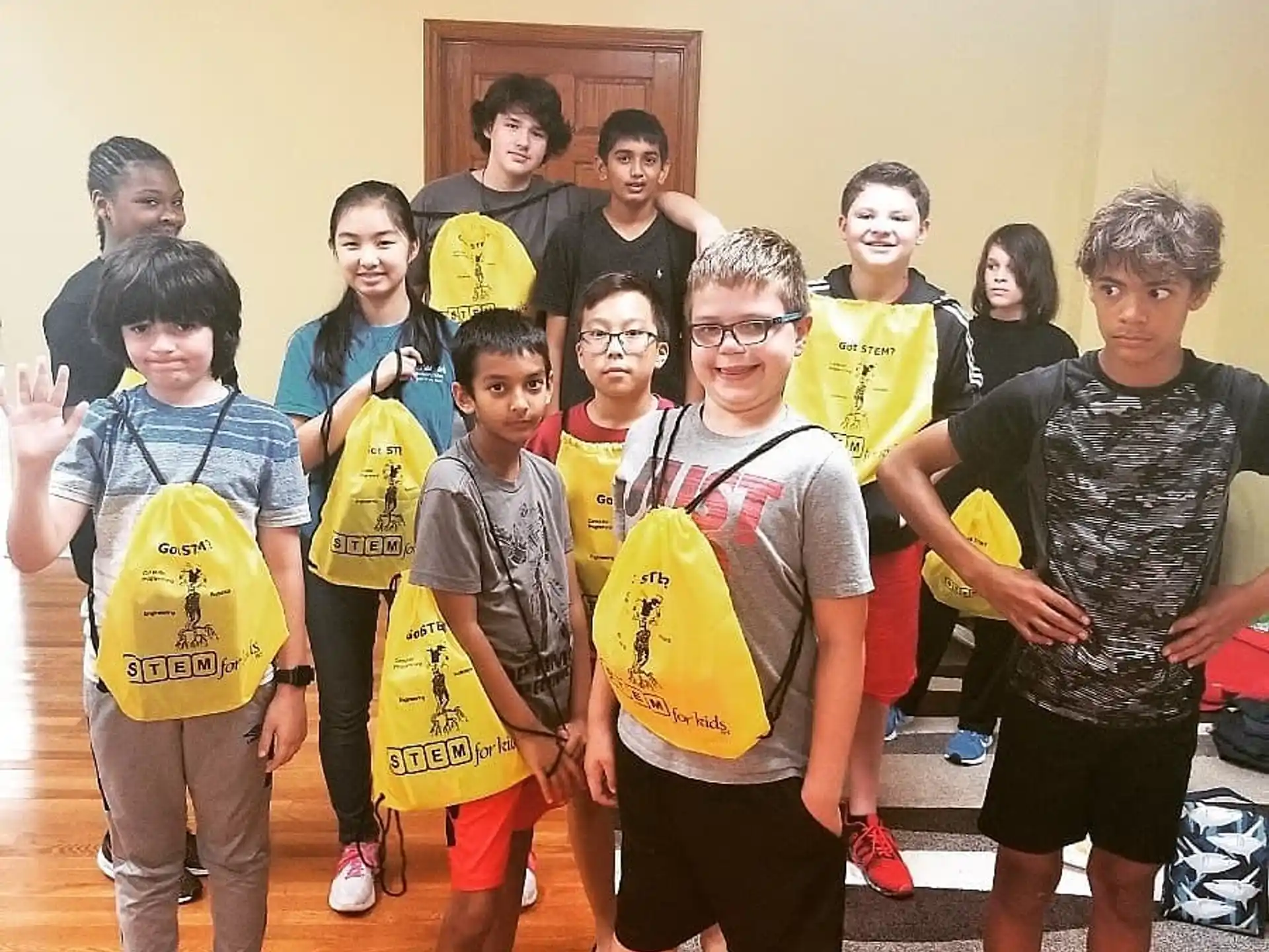 a group of kids wearing matching t-shirts and standing in a room