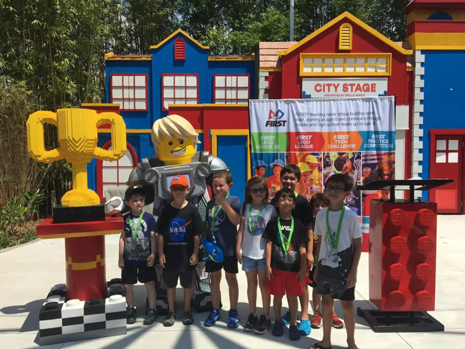 a group of kids posing for a photo in front of a yellow and red toy