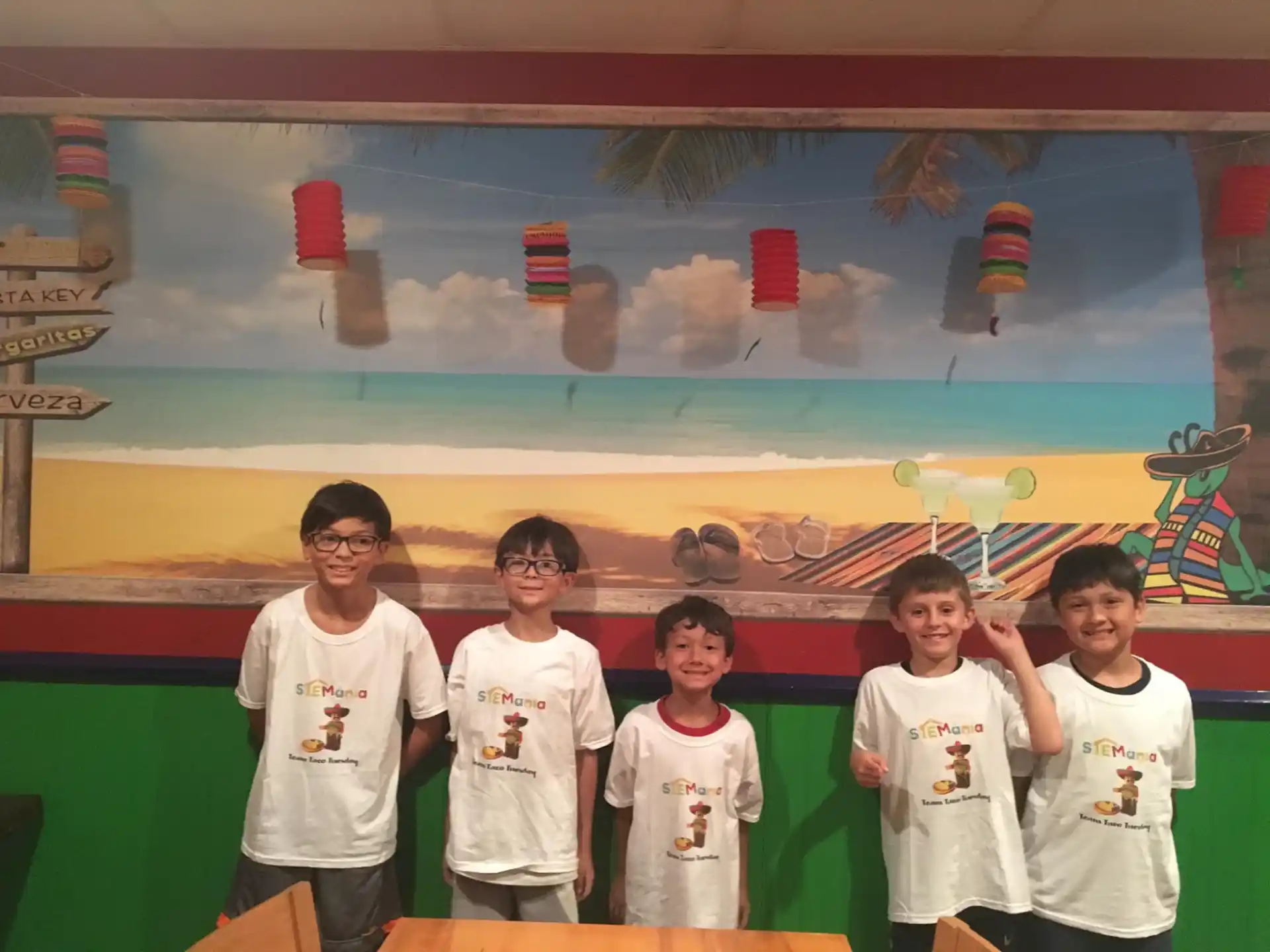 a group of people posing for a photo in front of a large screen