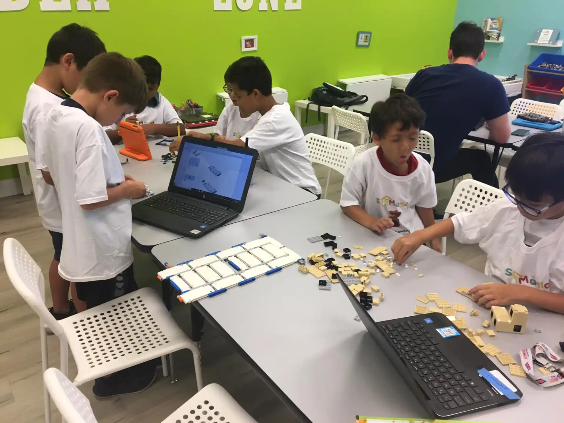 a group of people sitting around a table with laptops