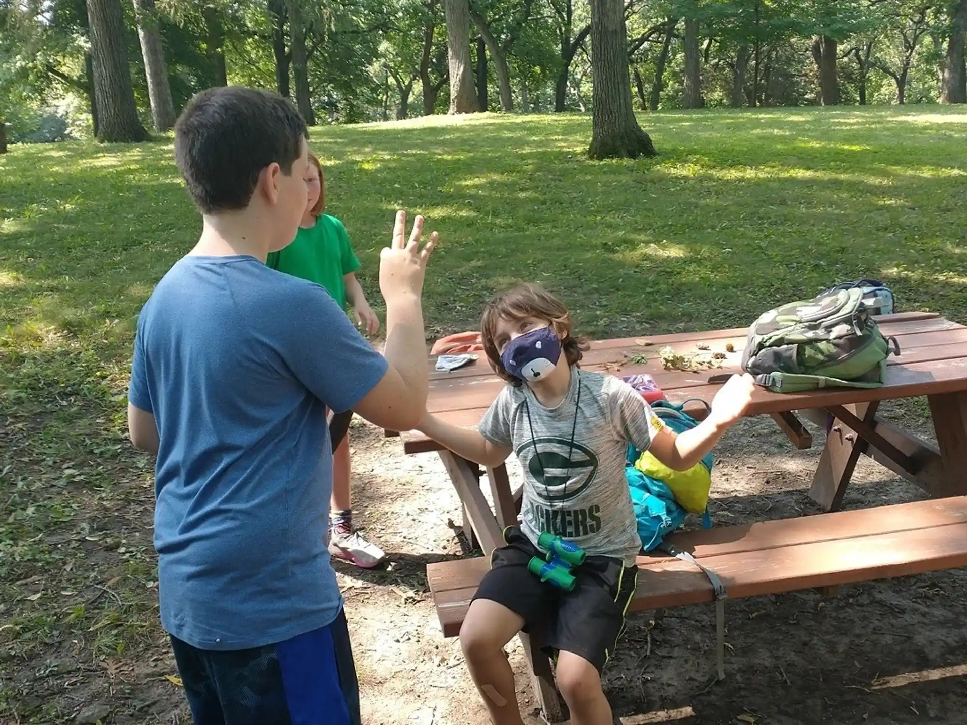 a man and a woman sitting at a picnic table in a park