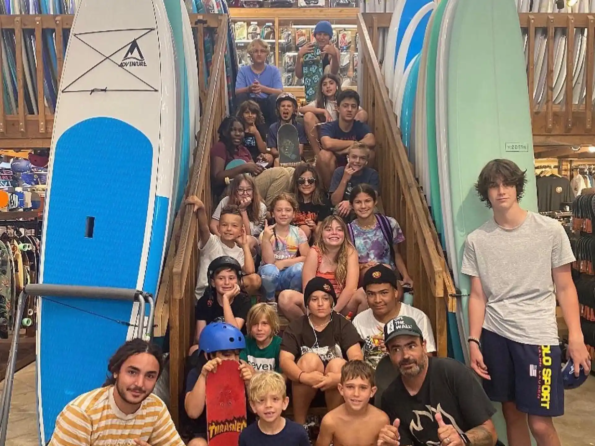 a group of people posing for a photo next to surfboards