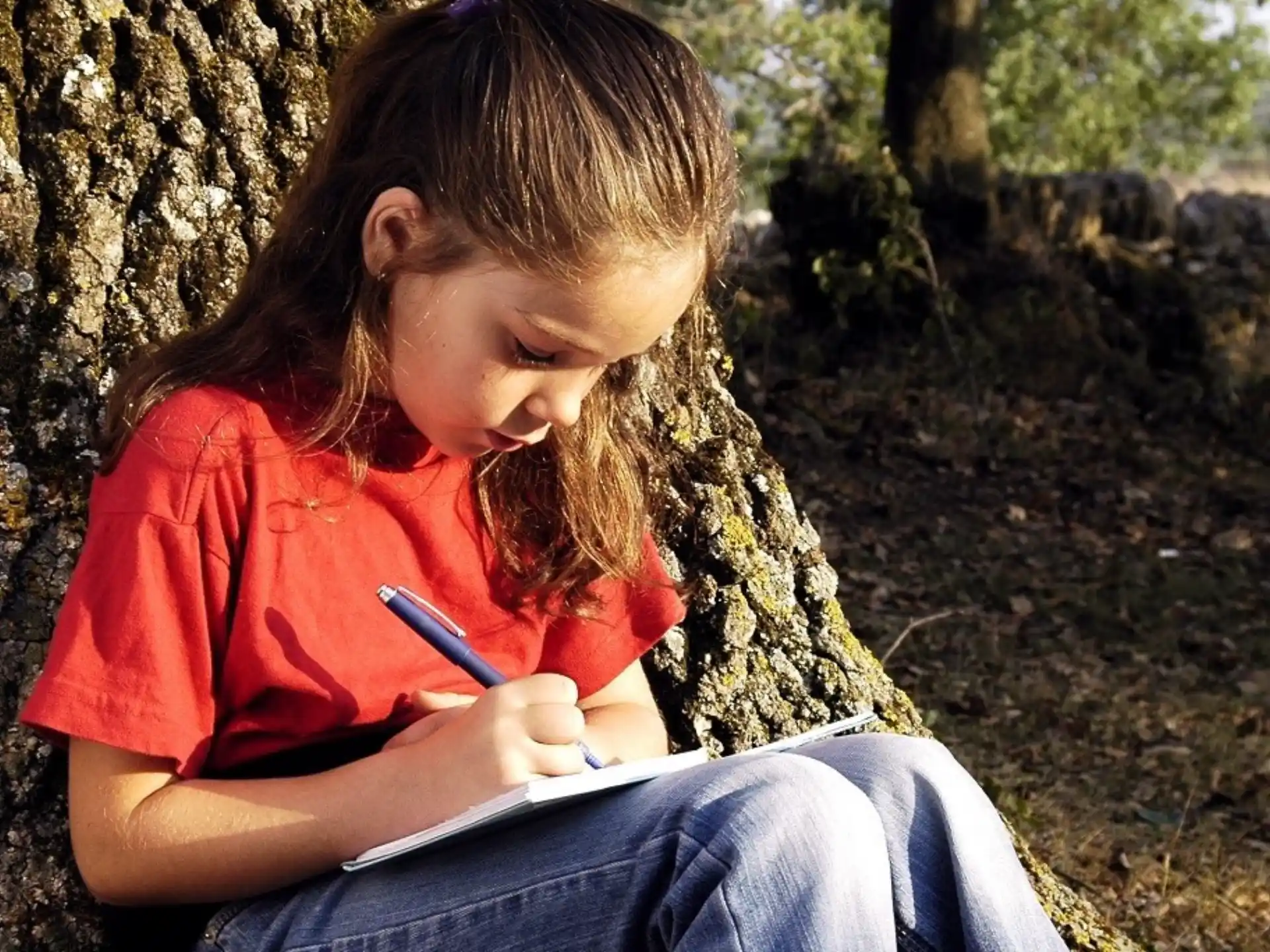 a girl writing on a piece of paper