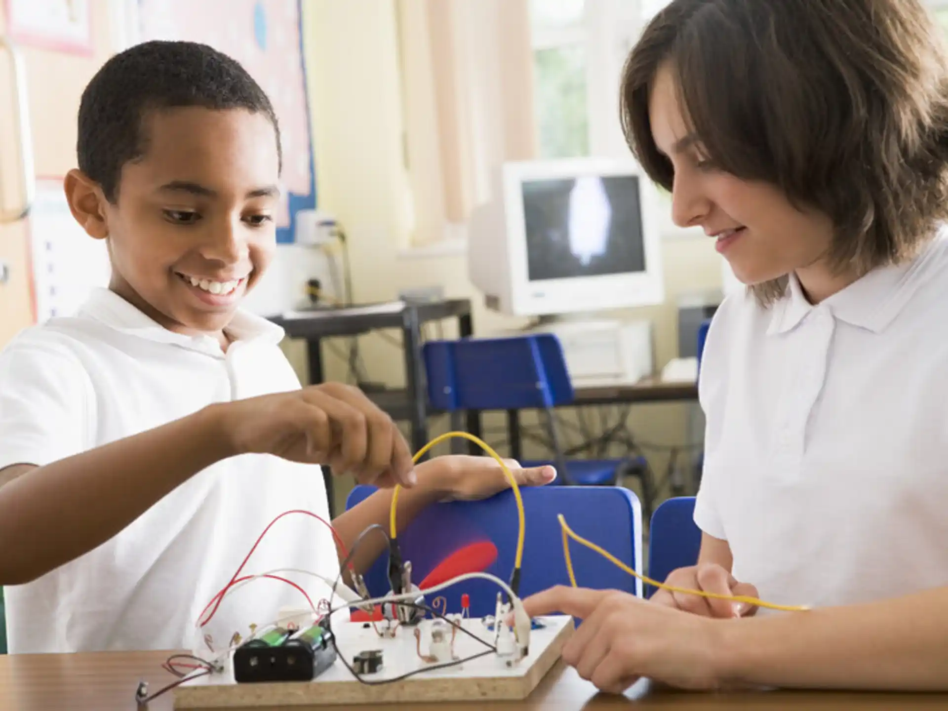 a couple of young boys working on a computer