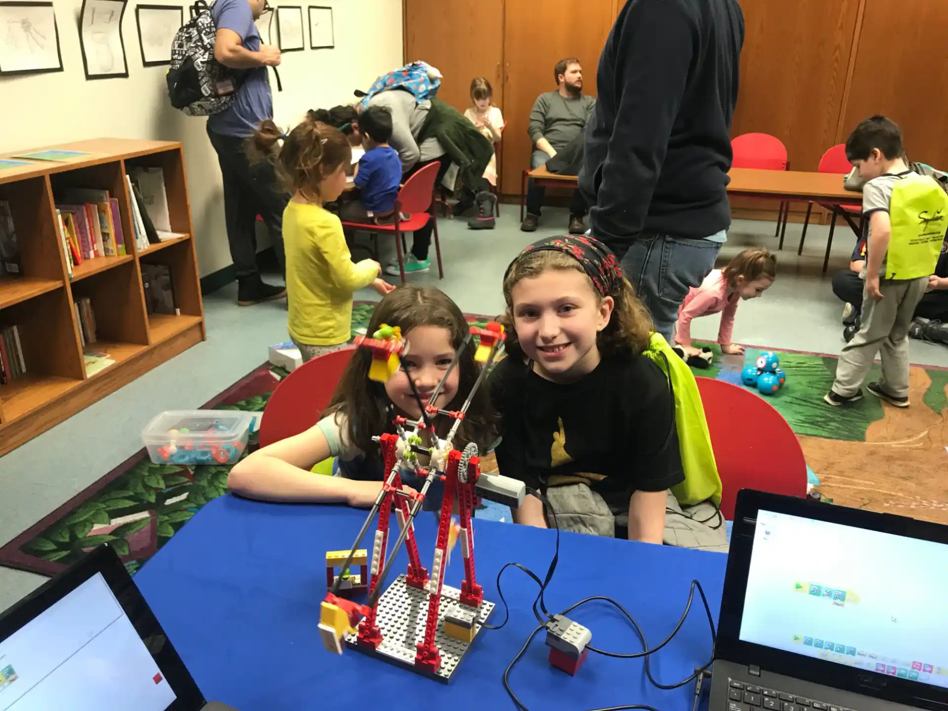 a group of children playing with a toy robot