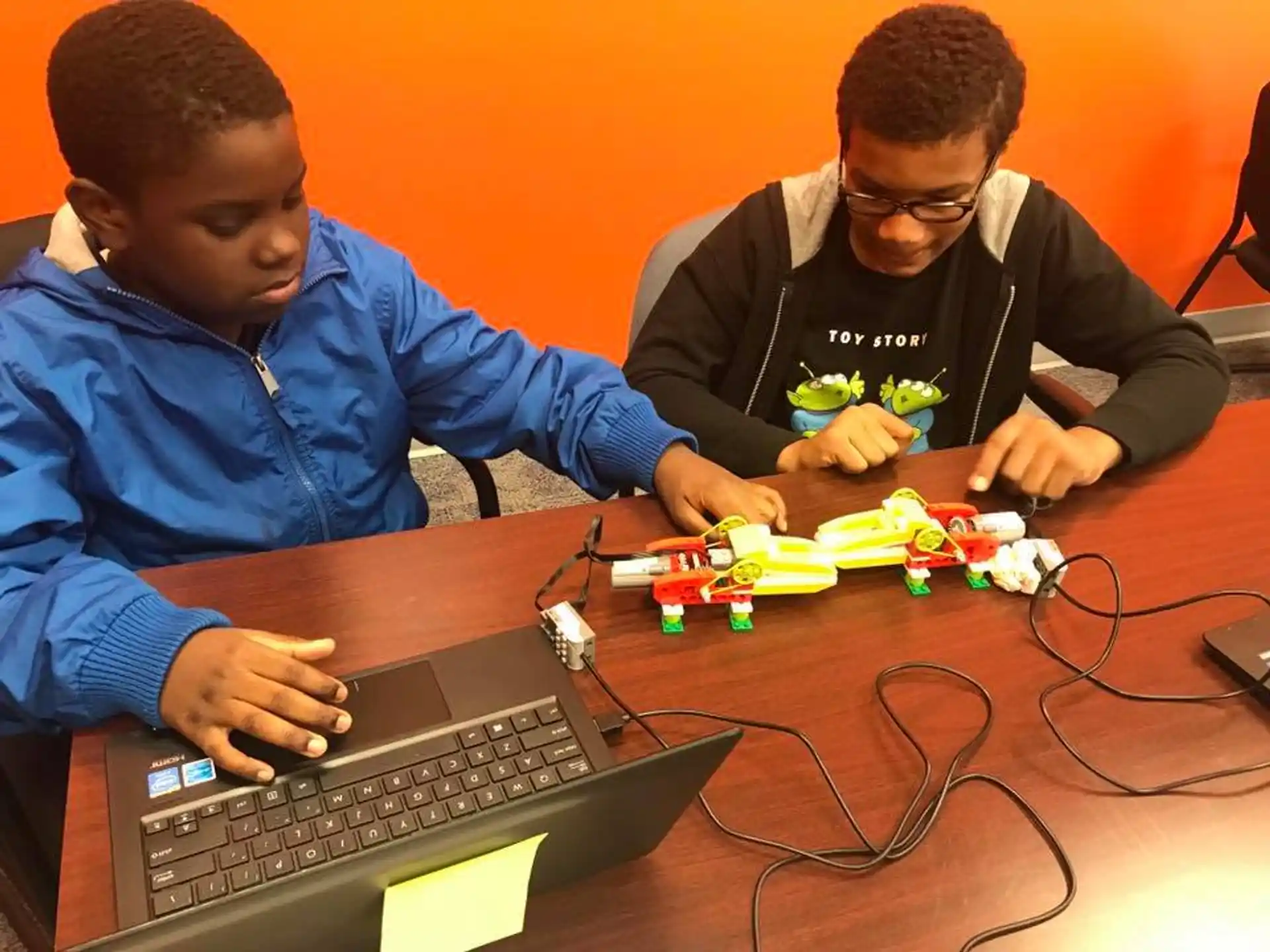 a couple of boys working on a computer