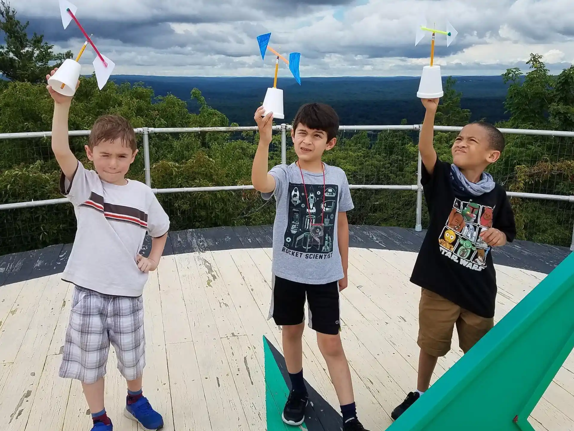 a group of boys holding up a couple of swords