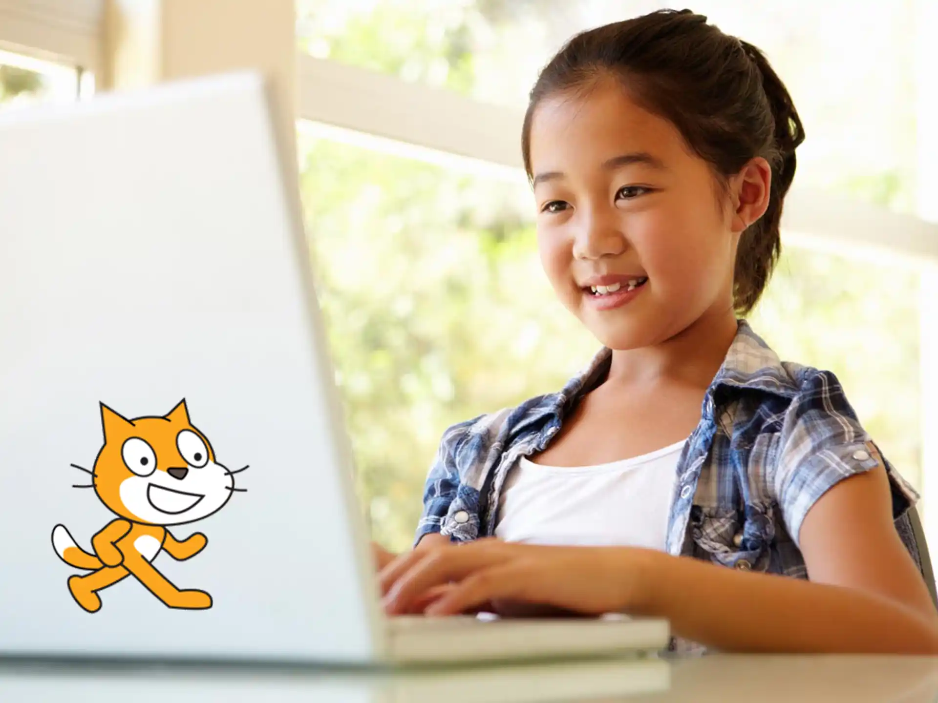 a young girl smiling at a computer