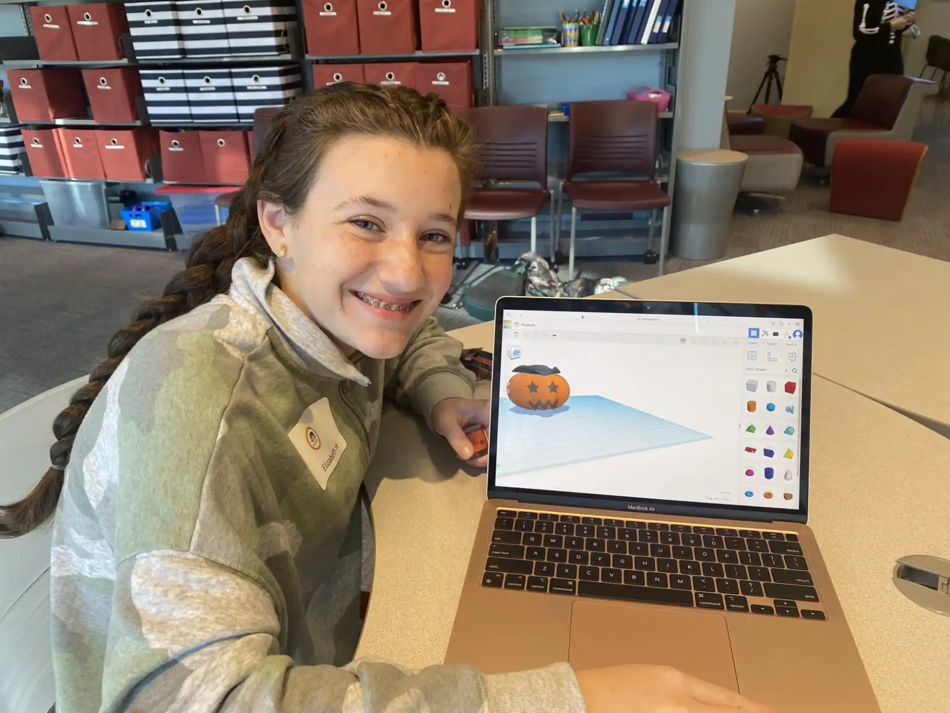 a girl smiling and holding a laptop