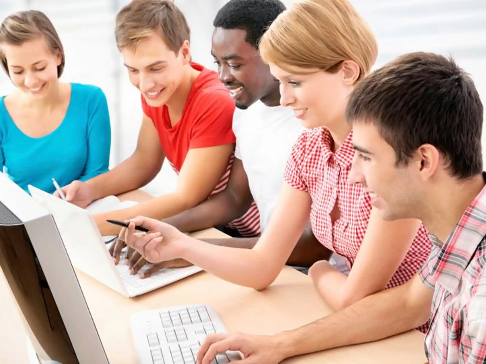 a group of people looking at a laptop