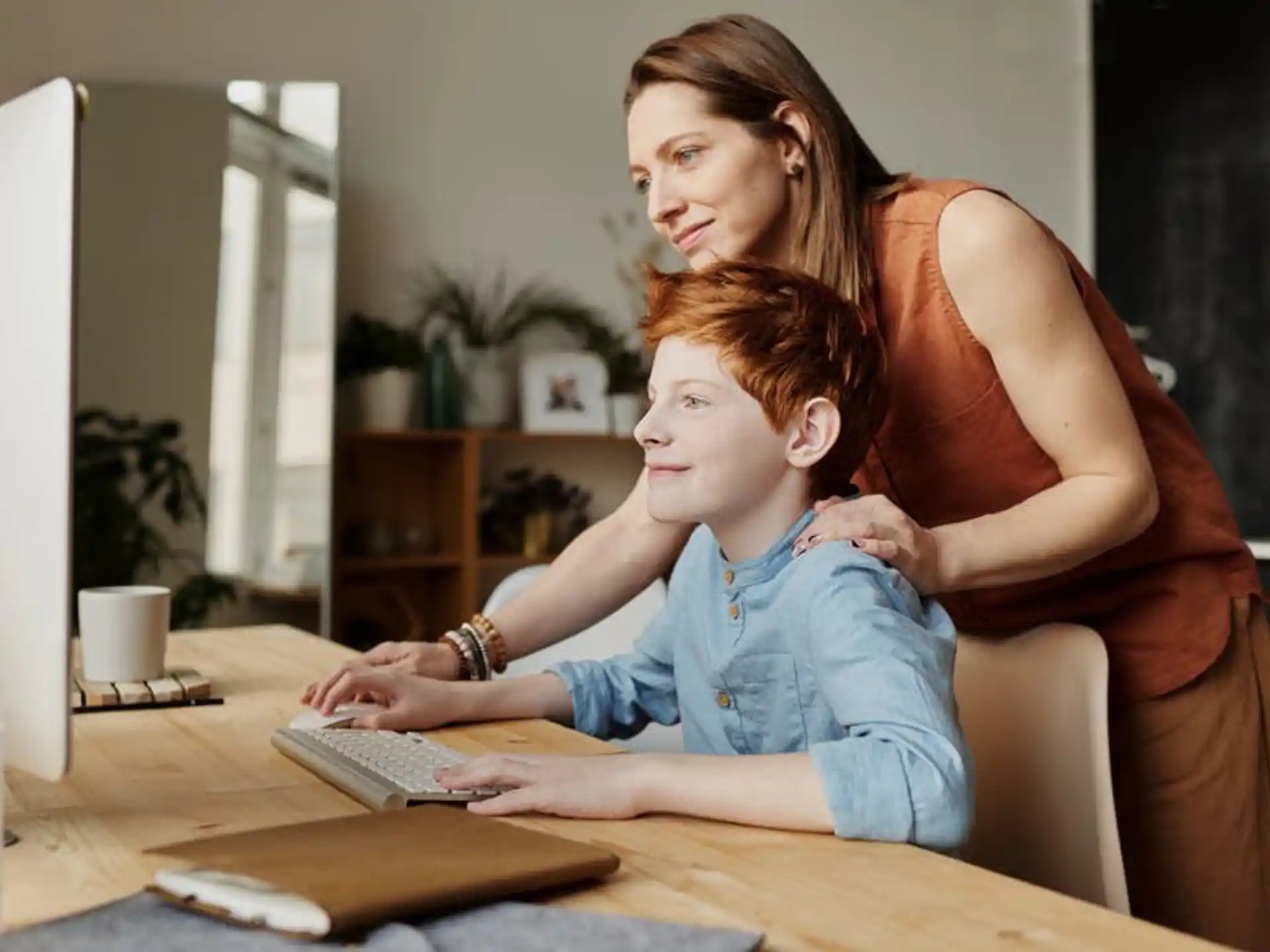 a woman and a child looking at a computer