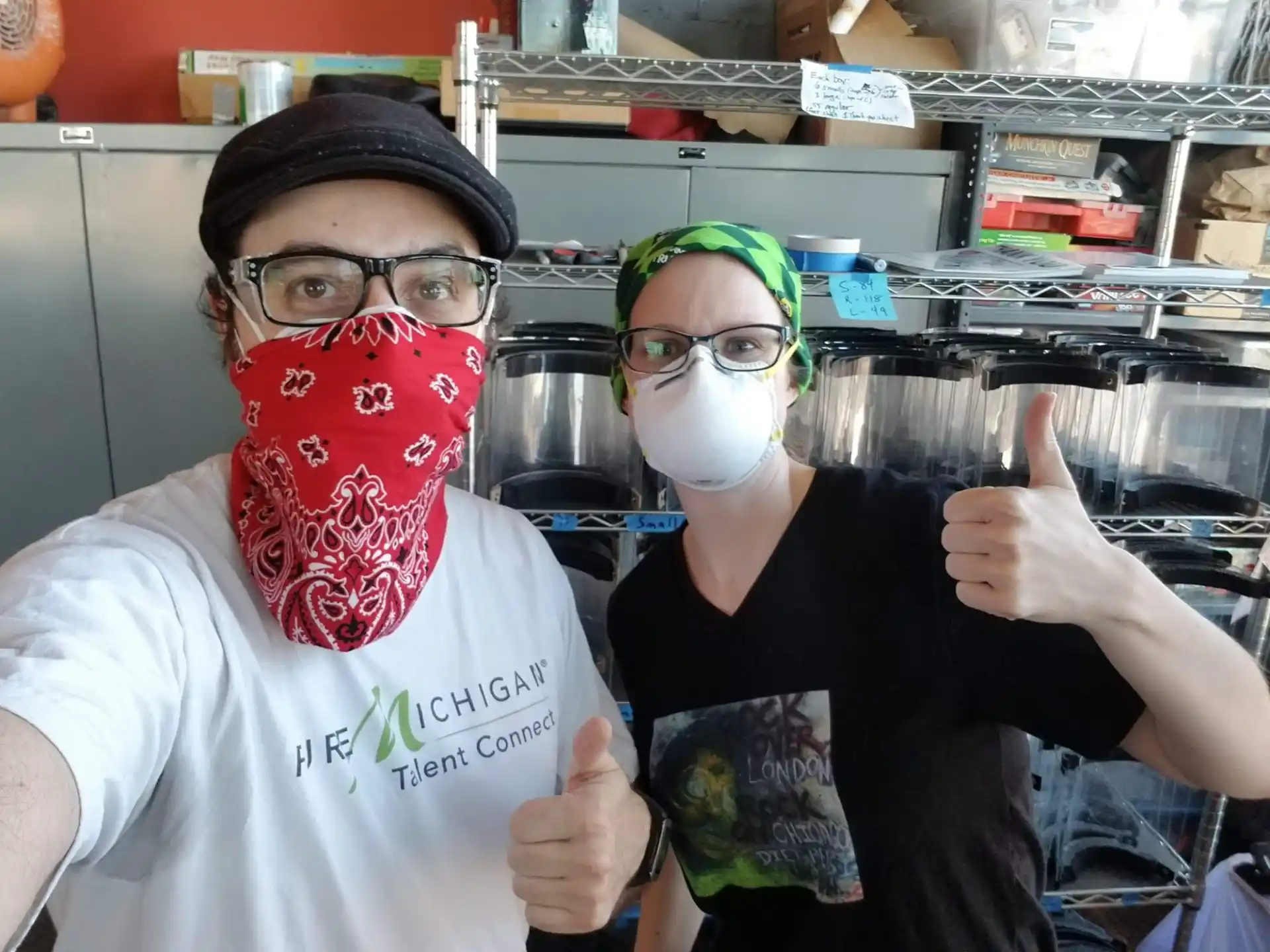 a couple of people wearing masks and holding up their fingers
